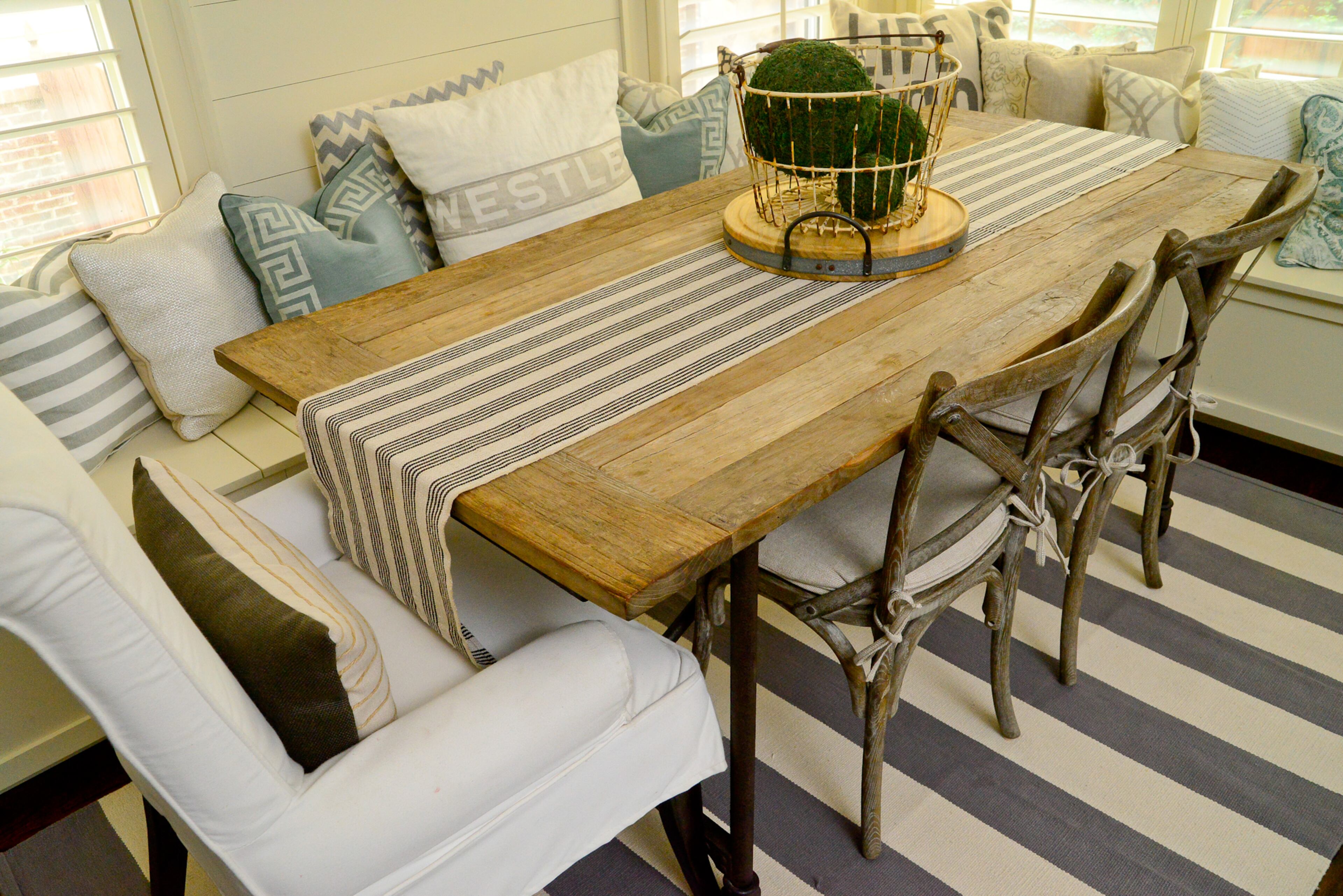 Textiles complete the look in the kitchen, which has a table runner from West Elm and pillows from Etsy, HomeGoods and Lisa Gabrielson Design at Queen of Hearts Antiques & Interiors. The table and chairs are from RH, formerly Restoration Hardware.
