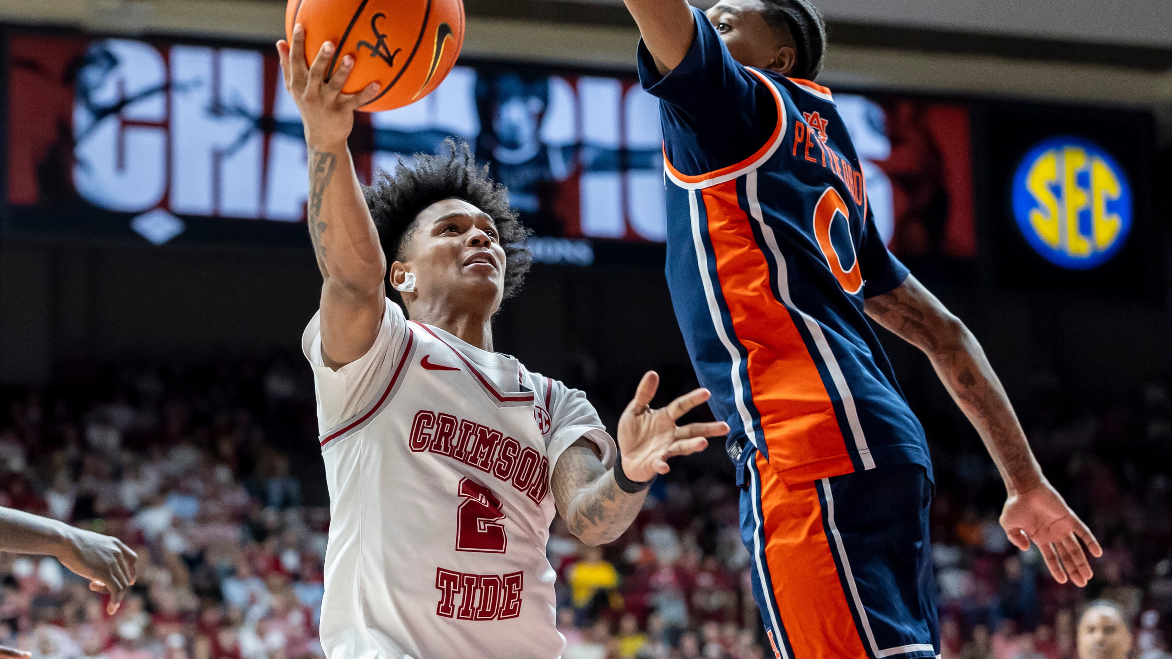Alabama guard Aden Holloway (2) looks to shoot past Auburn guard Tahaad Pettiford (0) during the second half of an NCAA college basketball game Saturday, March 7, 2026, in Tuscaloosa, Ala. (AP Photo/Vasha Hunt)