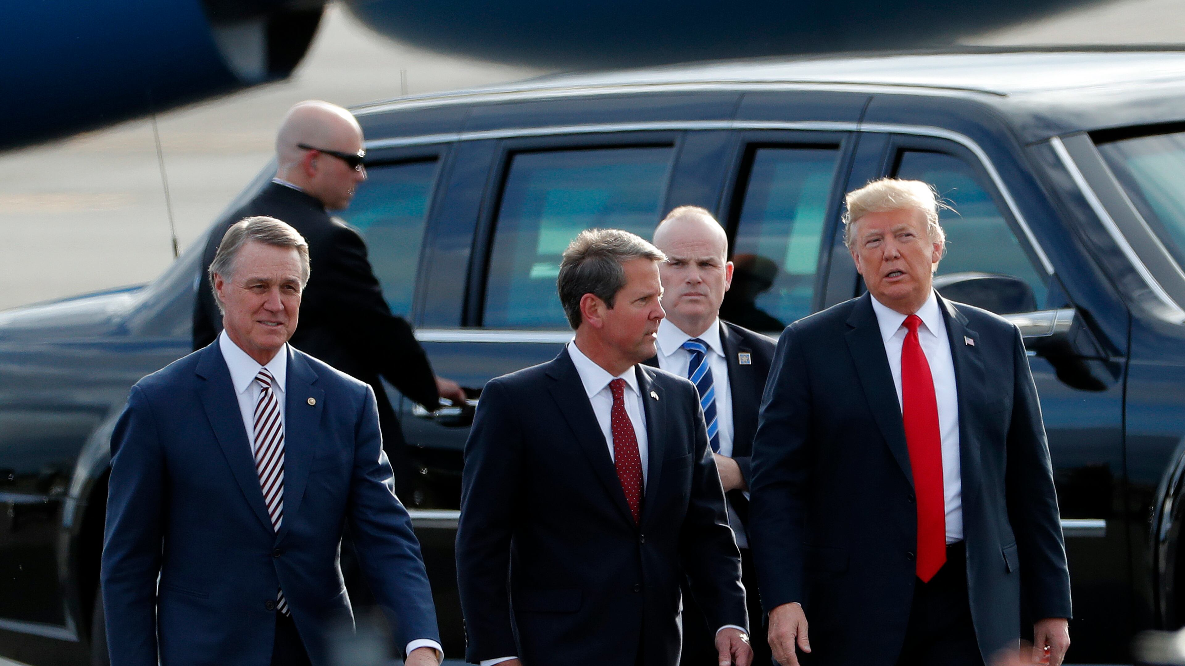 Georgia Republican gubernatorial candidate Brian Kemp, center, walks with President Donald Trump, right, and Sen. David Perdue (R-Ga) as Trump arrives for a rally Sunday, Nov. 4, 2018, in Macon, Ga. (AP Photo/John Bazemore)