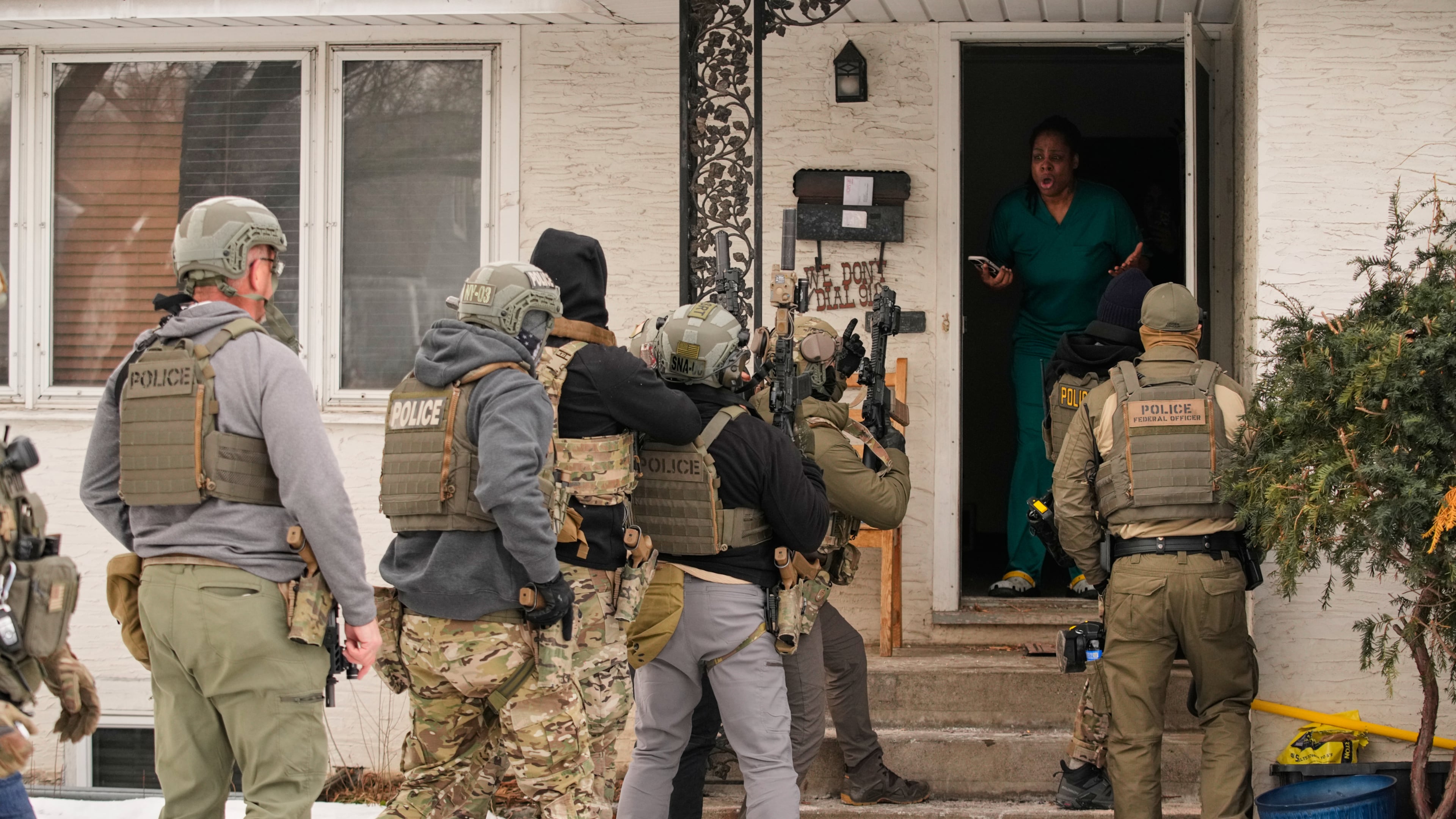 ADDS IDENTIFICATION: Teyana Gibson Brown, second from right, wife of Garrison Gibson, reacts after a federal immigration officer used a battering ram to break down a door before arresting Garrison Gibson, Sunday, Jan. 11, 2026, in Minneapolis. (AP Photo/John Locher)