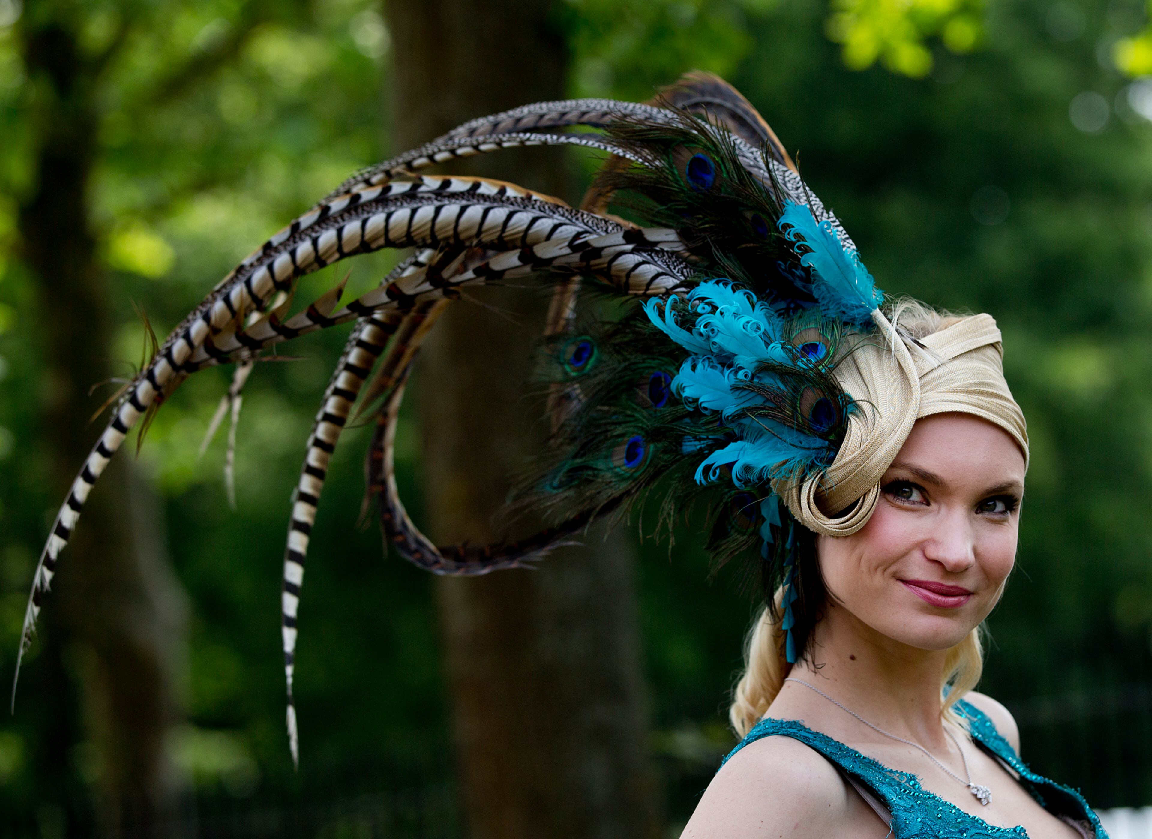Marinilia Smirnova poses for the media wearing a peacock feather hat on the second day of the Royal Ascot horse race meeting in Ascot, England, Wednesday, June 19, 2013. (AP Photo/Alastair Grant)