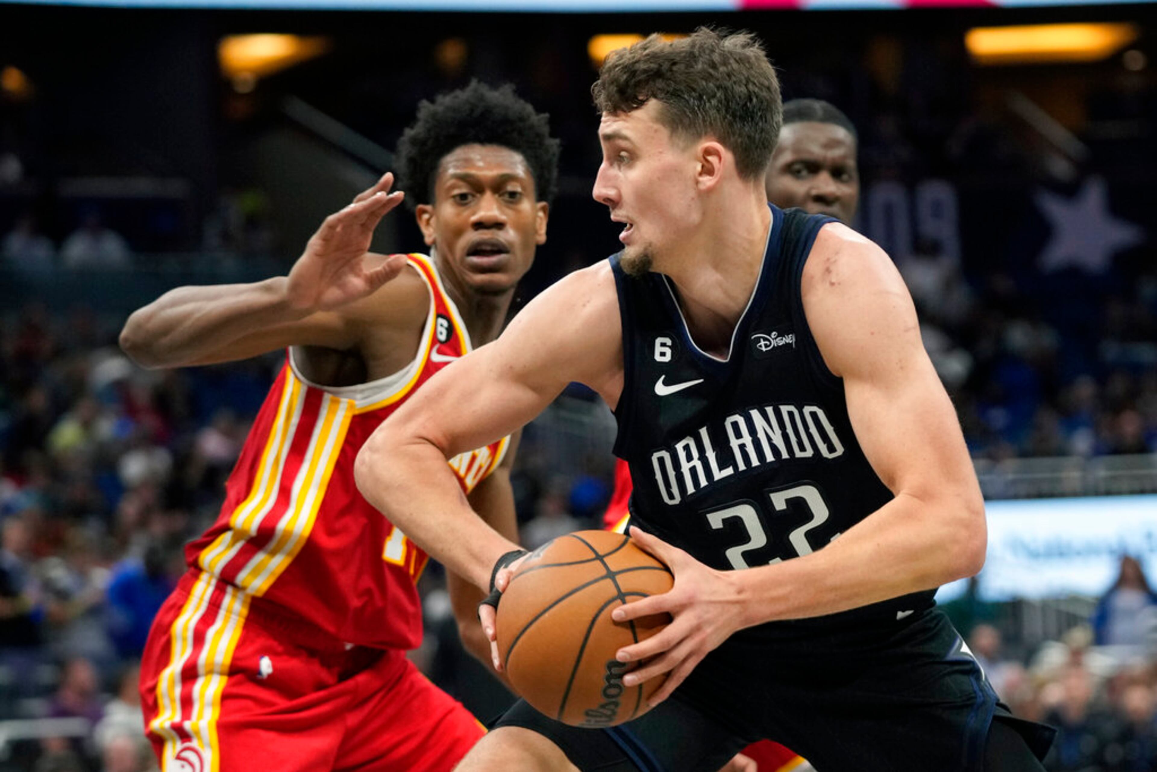 Orlando Magic's Franz Wagner (22) makes a move to the basket against Atlanta Hawks' De'Andre Hunter, left, during the second half of an NBA basketball game, Wednesday, Dec. 14, 2022, in Orlando, Fla. (AP Photo/John Raoux)