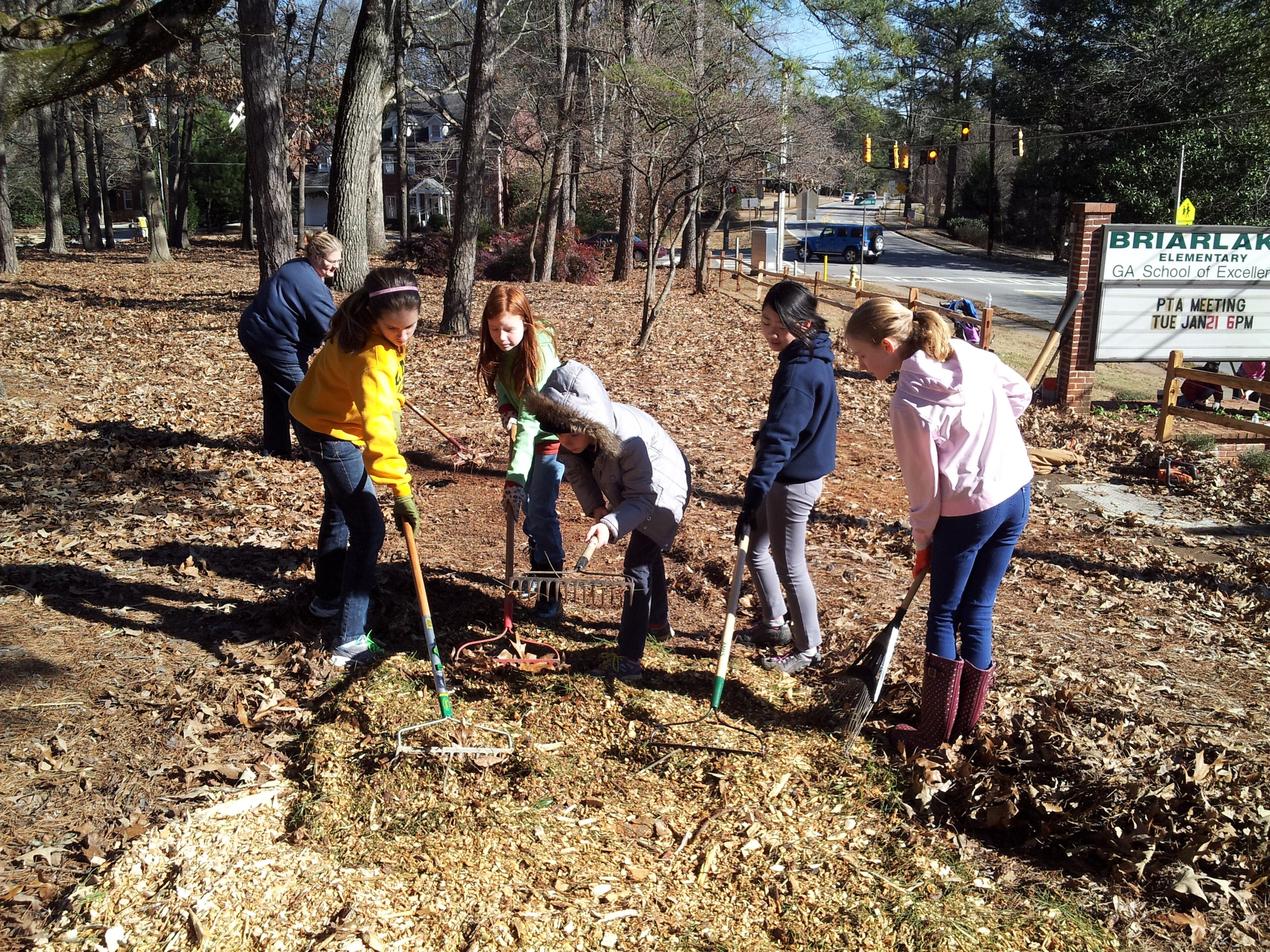 Students from Kittredge Magnet School for High Achievers, most of them Briarlake Elementary alums, help rake a path in front of their old school on MLK Day of Service, 2014.