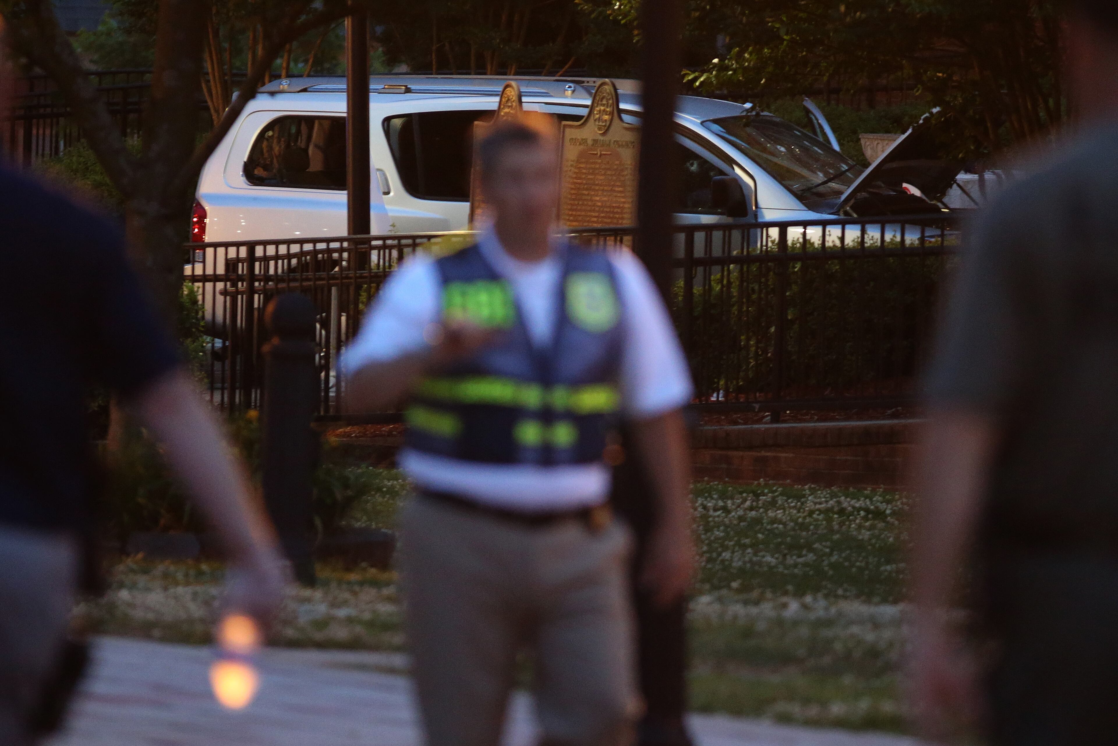 A GBI agent passes by the Nissan Armada Friday evening June 6, 2014 used by accused Forsyth County Courthouse shooter Dennis Marx earlier that morning. The shoot out left one deputy injured and the perpetrator dead.