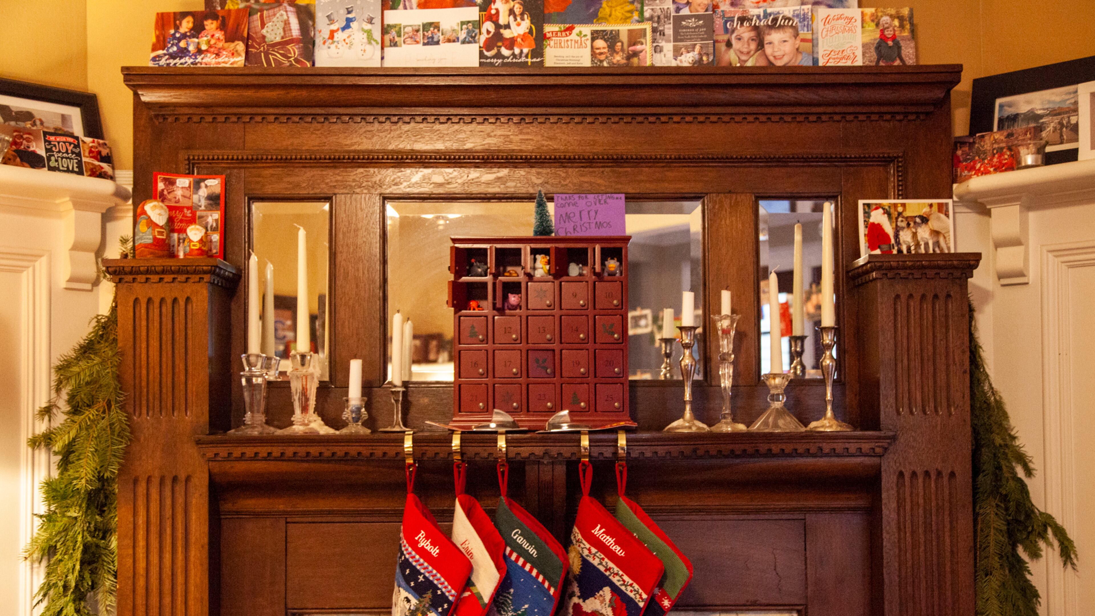 A cheerful holiday mantel is decorated with Christmas cards, an advent box and candles. Throughout the house, 420 flames are lit for the Grant Park Candlelight Tour of Homes, when all electric lights have to be turned off.