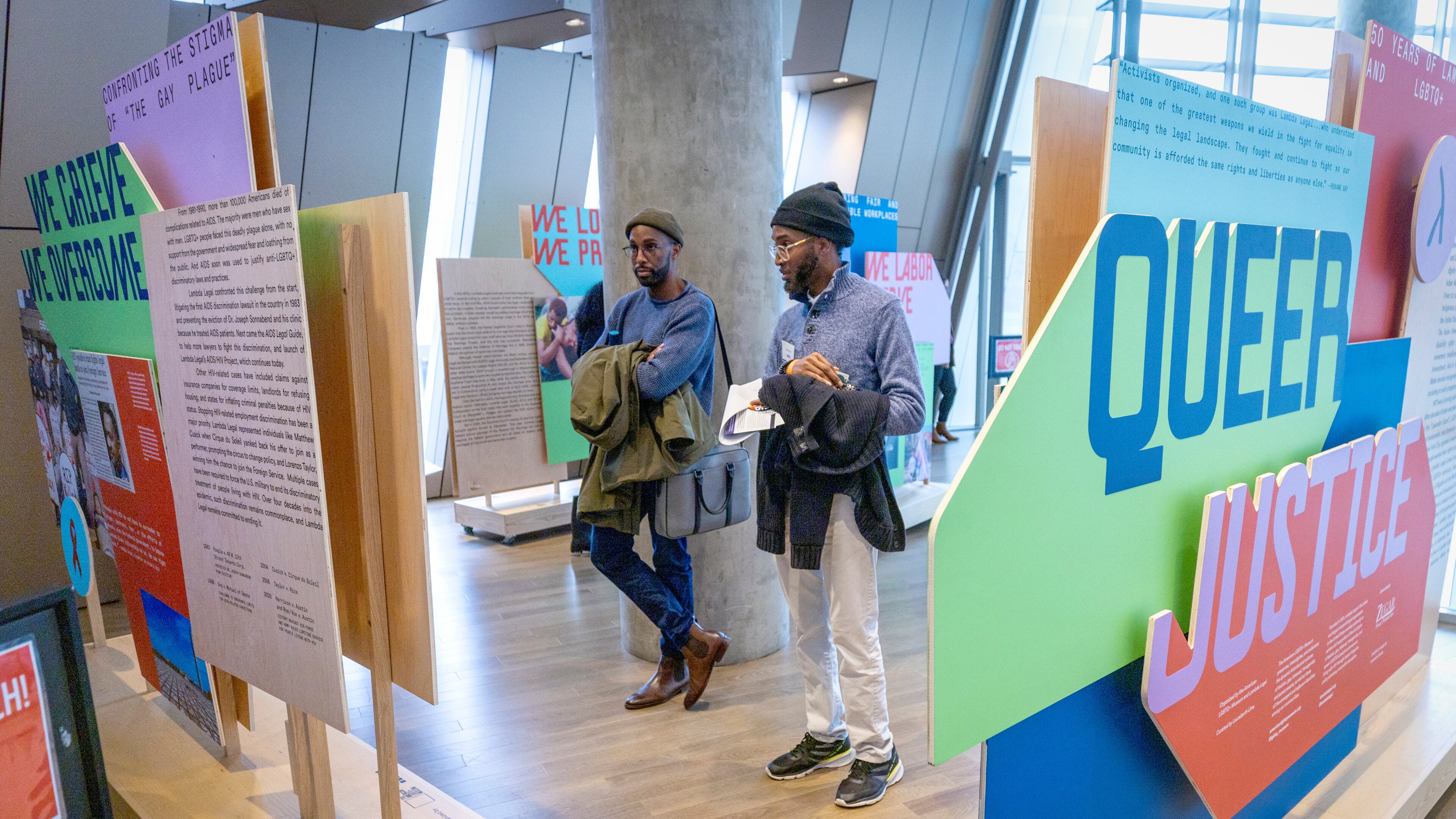 Elliott Abnatha (left) and Jai Kenon look over the traveling exhibit "Queer Justice: 50 Years of Lambda Legal and LGBTQ+ Rights" at the National Center for Civil and Human Rights Saturday, January 6, 2024. (Steve Schaefer/steve.schaefer@ajc.com)