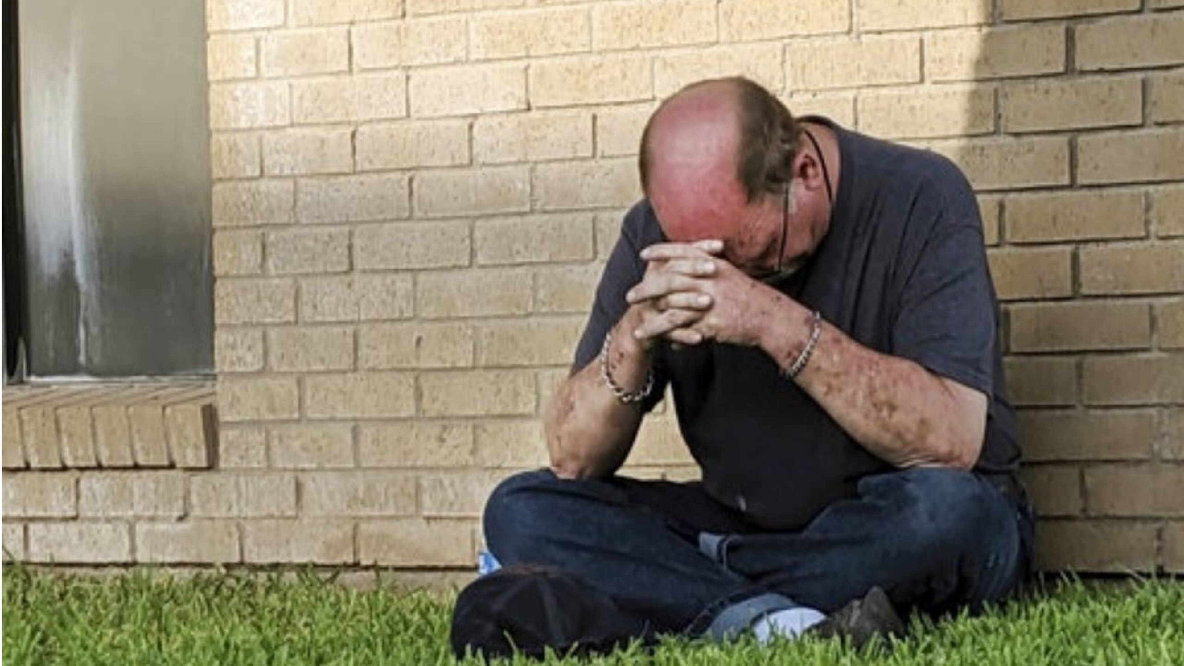 A man prays outside the Medical Center Hospital emergency room in Odessa, Texas, after Saturday's mass shooting in Odessa and Midland.
