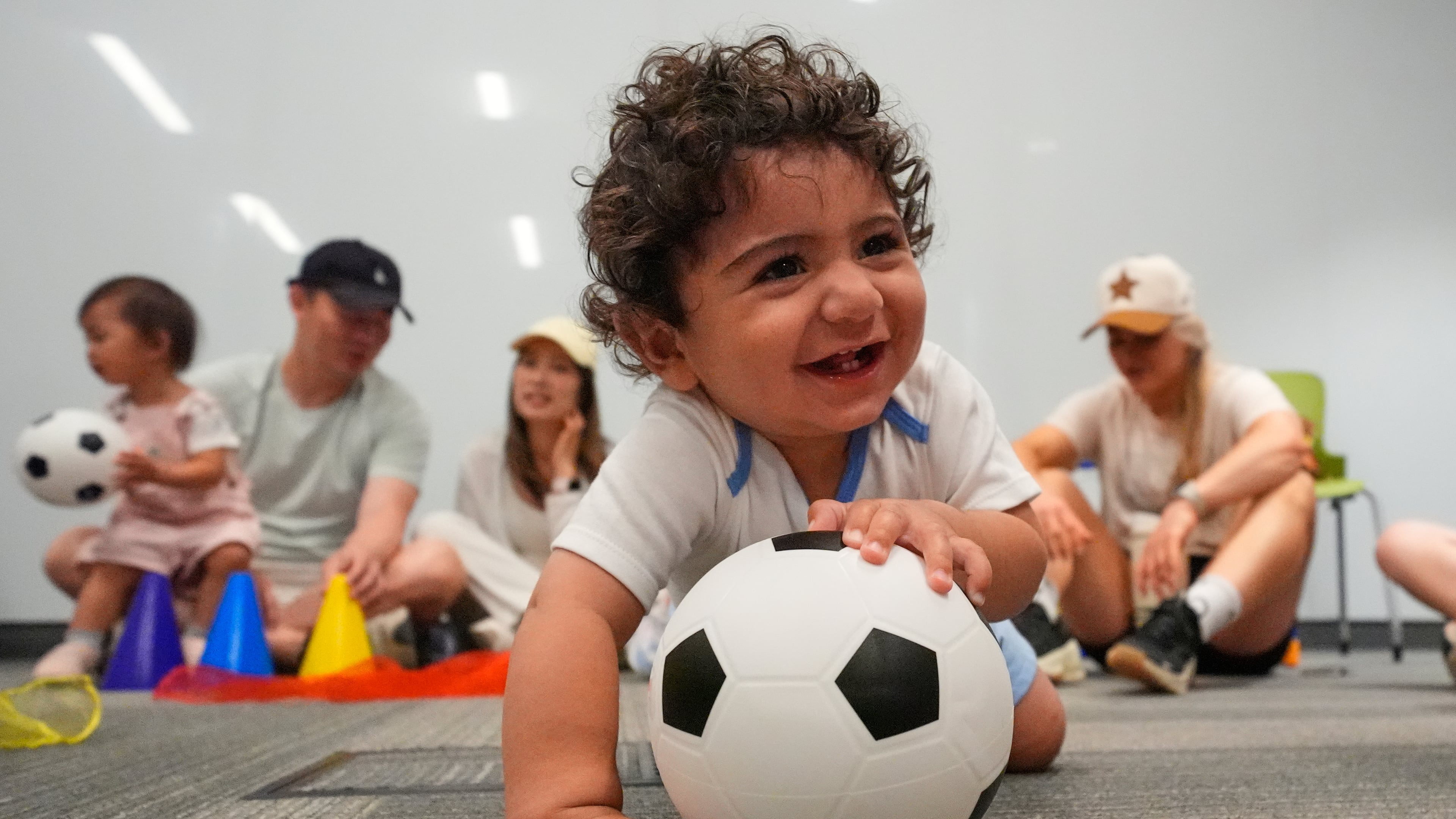 Ten-month-old Zain Fawaz plays with a soccer ball at a program introducing toddlers to the sport ahead of the World Cup soccer tournament Thursday, June 4, 2026, in Lenexa, Kan. (AP Photo/Charlie Riedel)