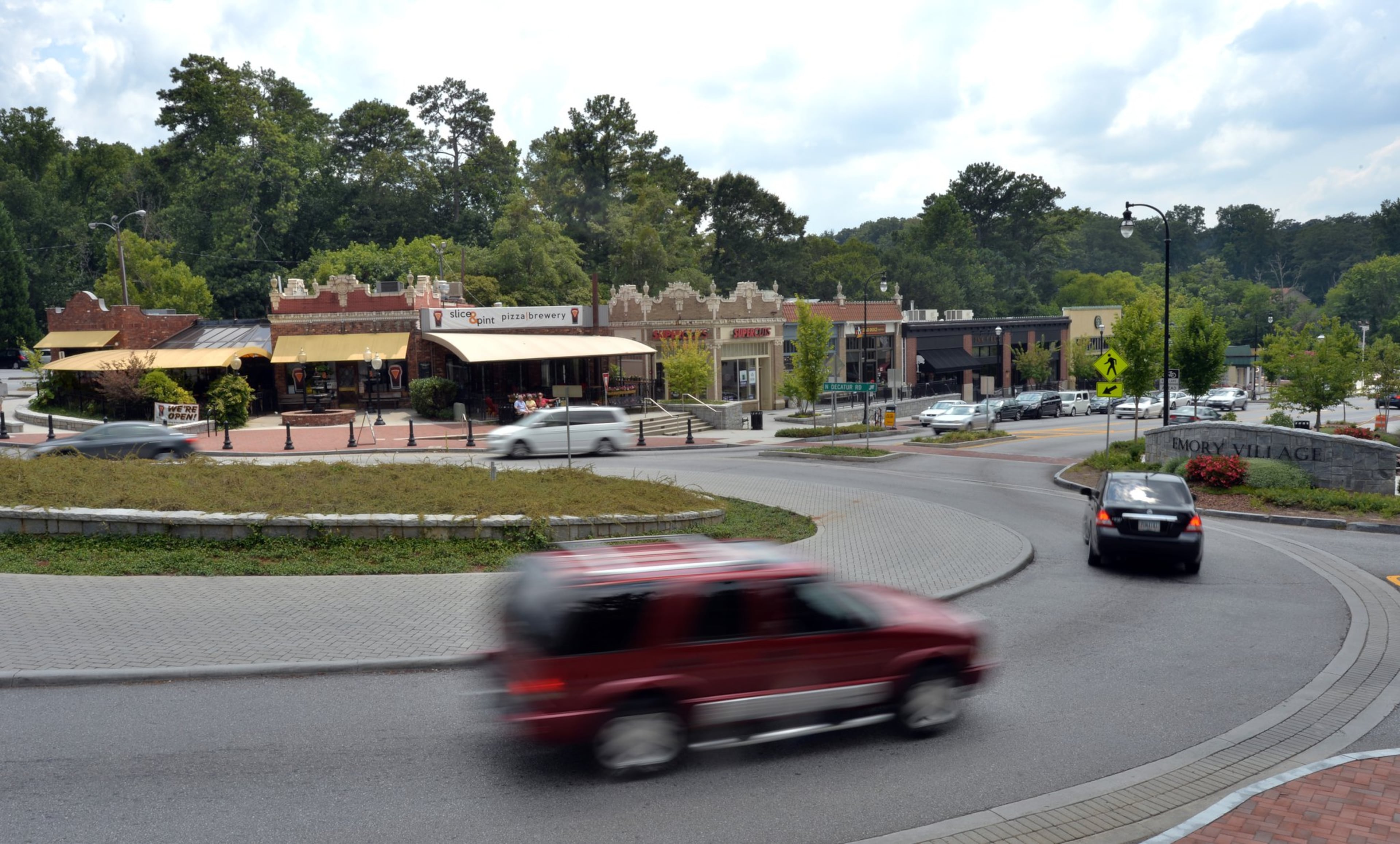 Cars drive through a traffic circle, shops and restaurants in Emory Village near an entrance to Emory University in Atlanta in this 2014 file photo. Traffic is a major concern in the university’s master plan.