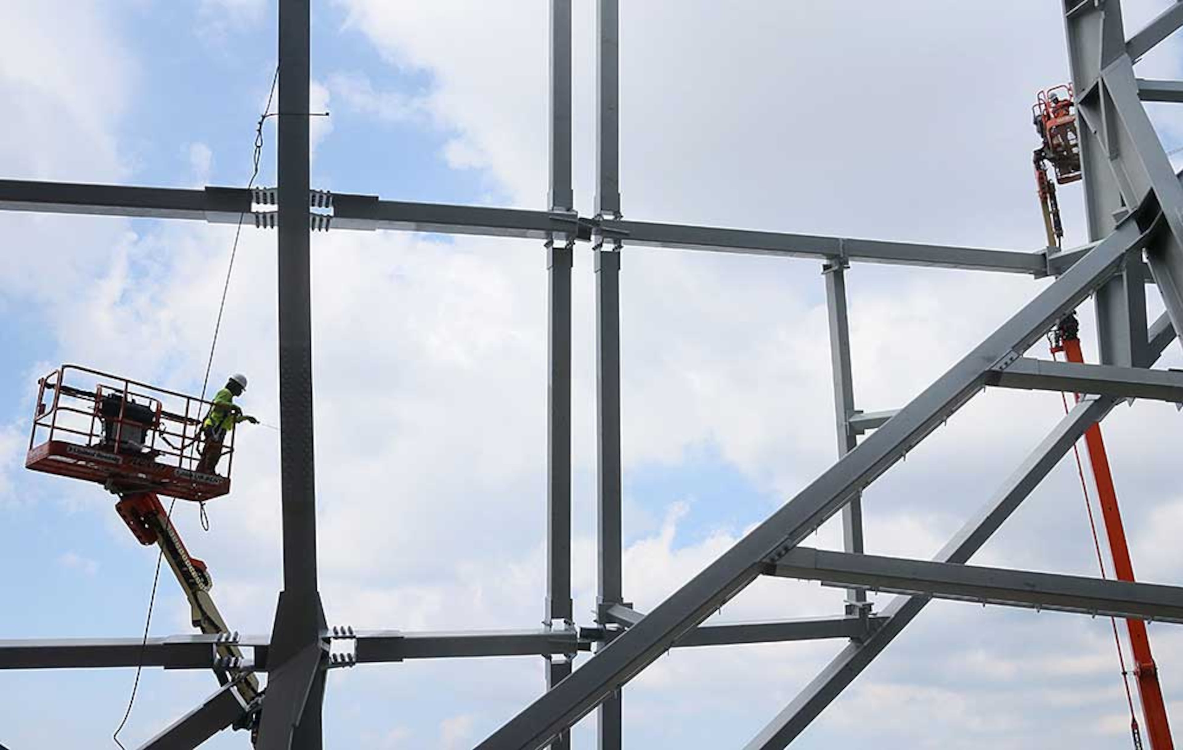 Looking outward from the upper concourse, erection of the facade steel is visible around the exterior of the stadium.