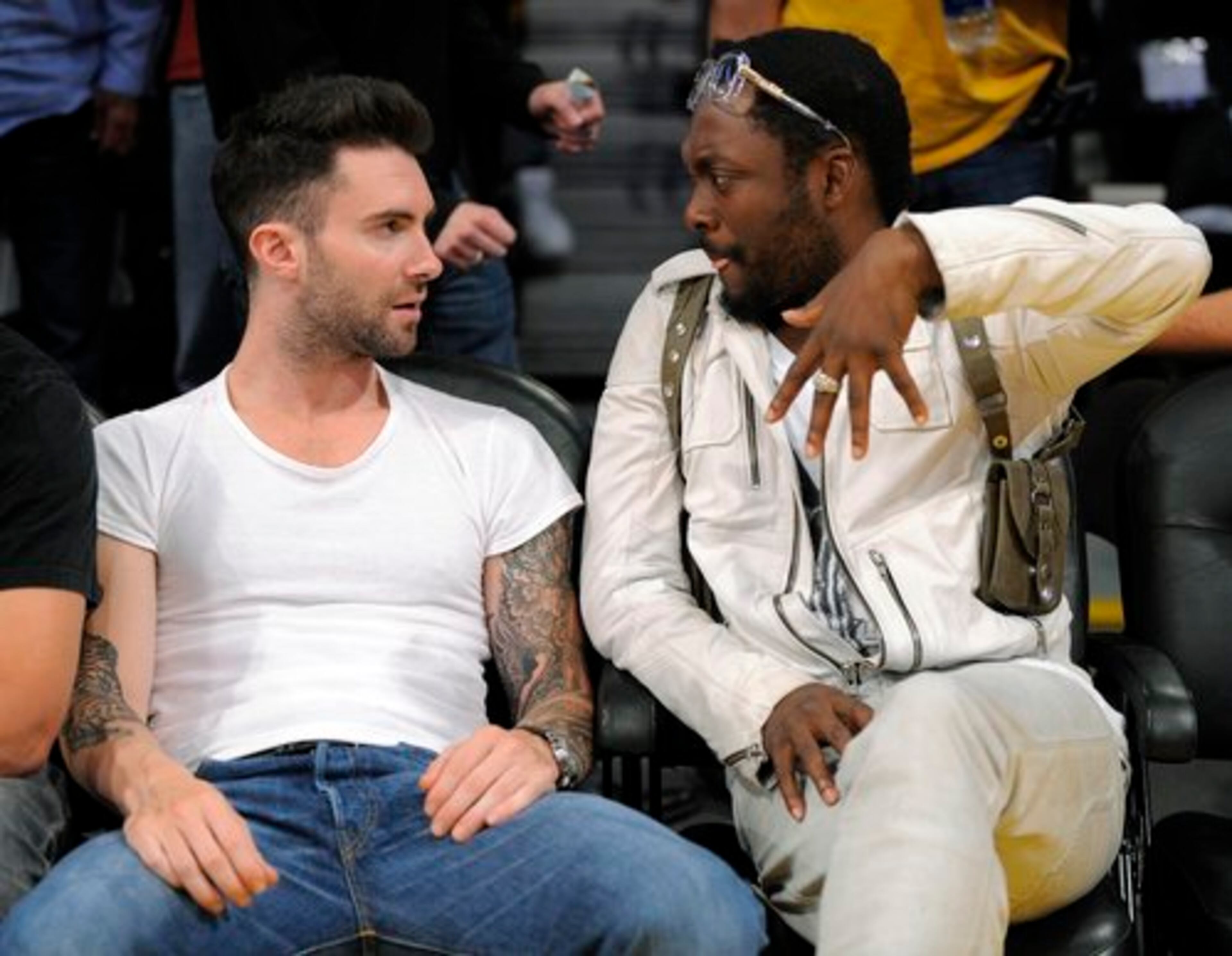 Singer will.i.am of the hip-hop group Black Eyed Peas shows singer-songwriter and Maroon 5 frontman Adam Levine how to hold your fingers pointing downward.