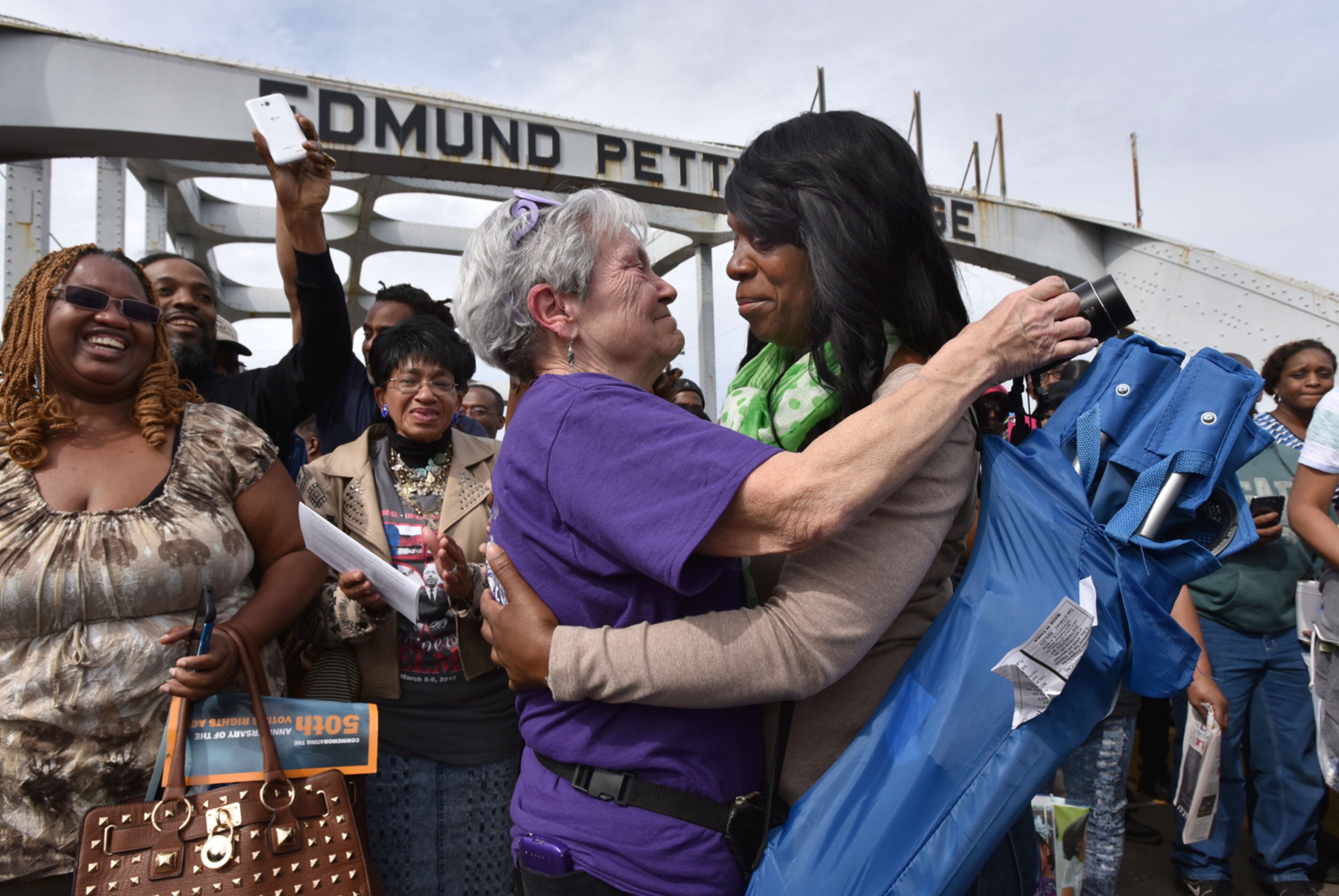 BLOODY SUNDAY RE-ENACTMENT--March 8, 2015 Selma, Alabama - Lynne Abbott (foreground left), of Huntsville, Alabama, and Verna Pearson, of Tampa, Florida, embrace in the middle of the Edmund Pettus Bridge as they take a symbolic walk on Sunday, March 8, 2015. Thousands of people took part in a bridge crossing reenactment in Selma on Sunday to commemorate the 50th anniversary of Bloody Sunday. HYOSUB SHIN / HSHIN@AJC.COM