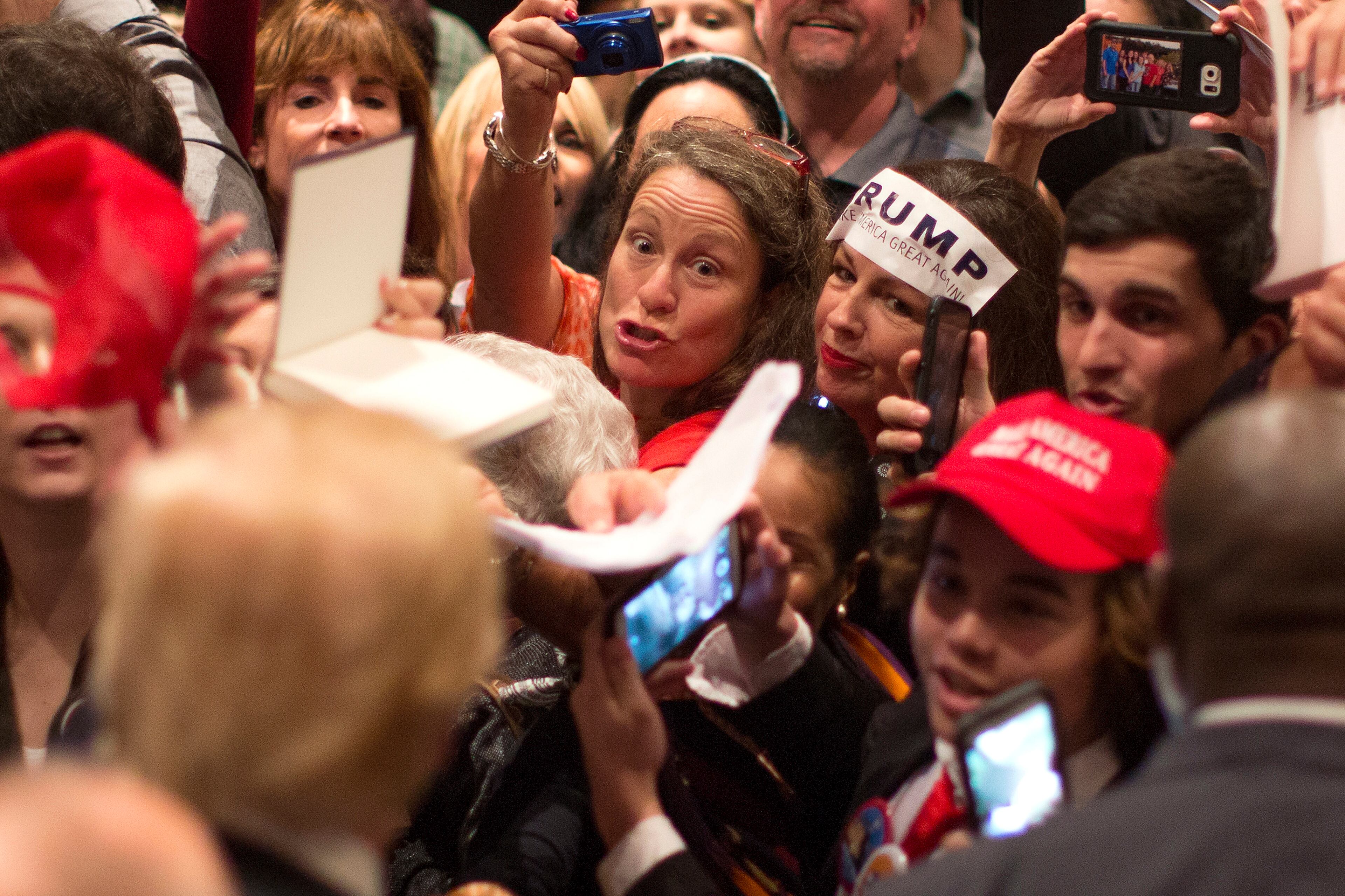 Supporters clammer for Republican presidential candidate Donald Trump's autograph during a campaign stop in Hilton Head Island, S.C., Wednesday, Dec. 30, 2015. (AP Photo/Stephen B. Morton)