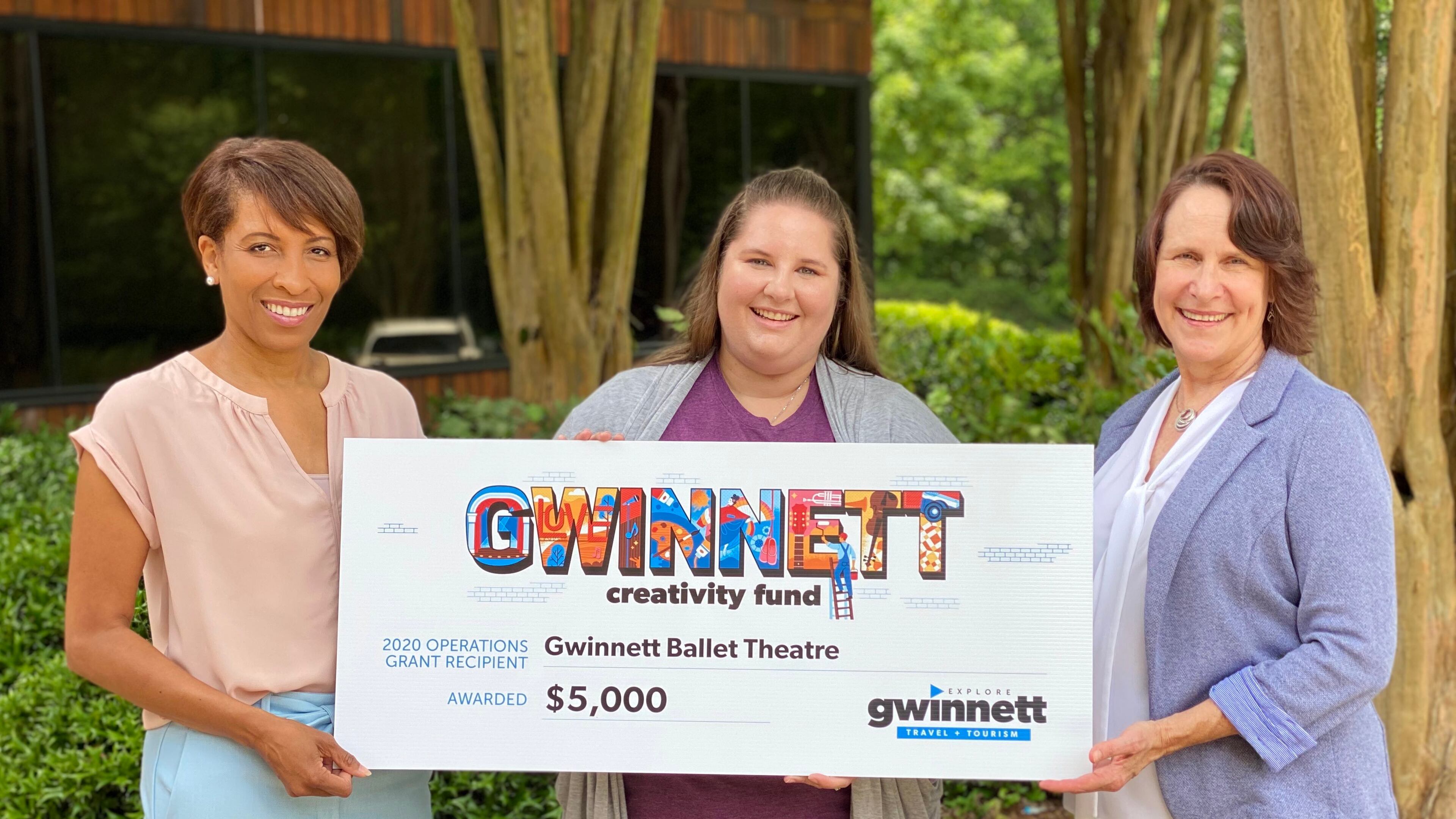 Representatives from the Gwinnett Ballet Theatre accept a Gwinnett Creativity Fund grant from Explore Gwinnett Marketing Project Manager Haleigh Staalner. (Courtesy Explore Gwinnett)