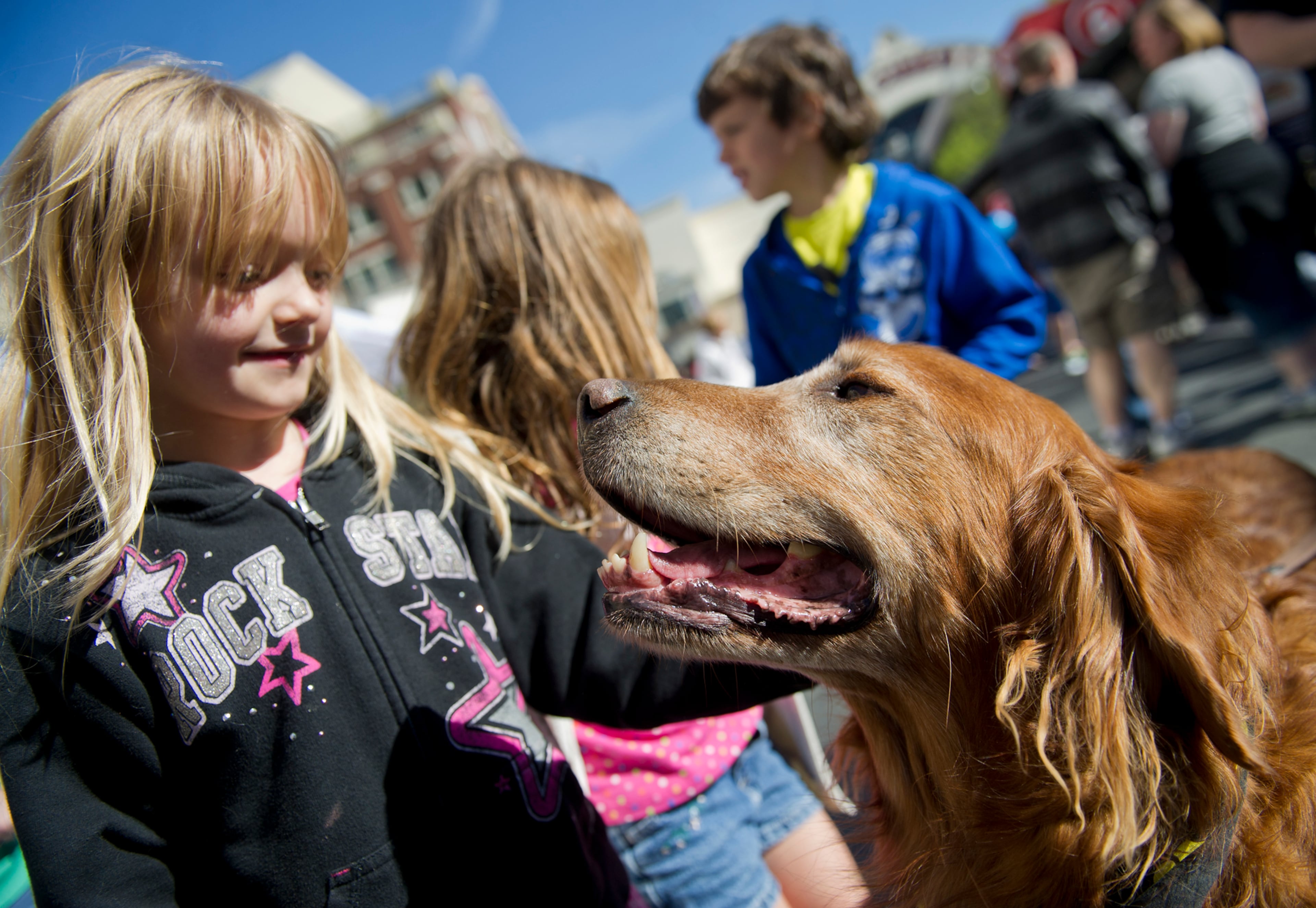 Duke, a golden retreiver, gets some love from Skyelar Thomas before the Atlanta Humane Society's 23rd annual Pet Parade at Atlantic Station in Atlanta Saturday, April 13, 2013. Hundreds of pets and their owners participated in the parade which helps generate awareness in the community and support fundraising for animal shelters. On average, it costs the Atlanta Humane Society approximately $300 to find a home for the each animal in their care.