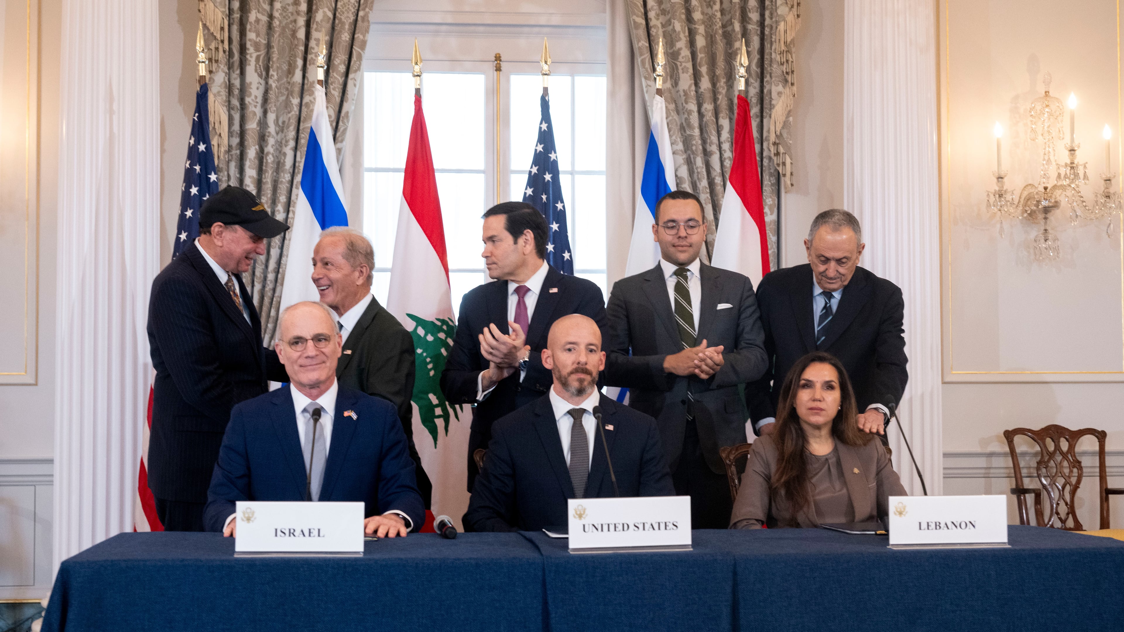 Secretary of State Marco Rubio and others watch, as seated from left, Israel's Ambassador to the U.S. Yechiel Leiter, counselor Dan Holler, and Lebanon's Ambassador to the U.S. Nada Hamadeh, sign a framework agreement, described as a first step toward peace following months of conflict between Israel and the Lebanese militant group Hezbollah, at the State Department, Friday, June 26, 2026, in Washington. (AP Photo/Kevin Wolf)