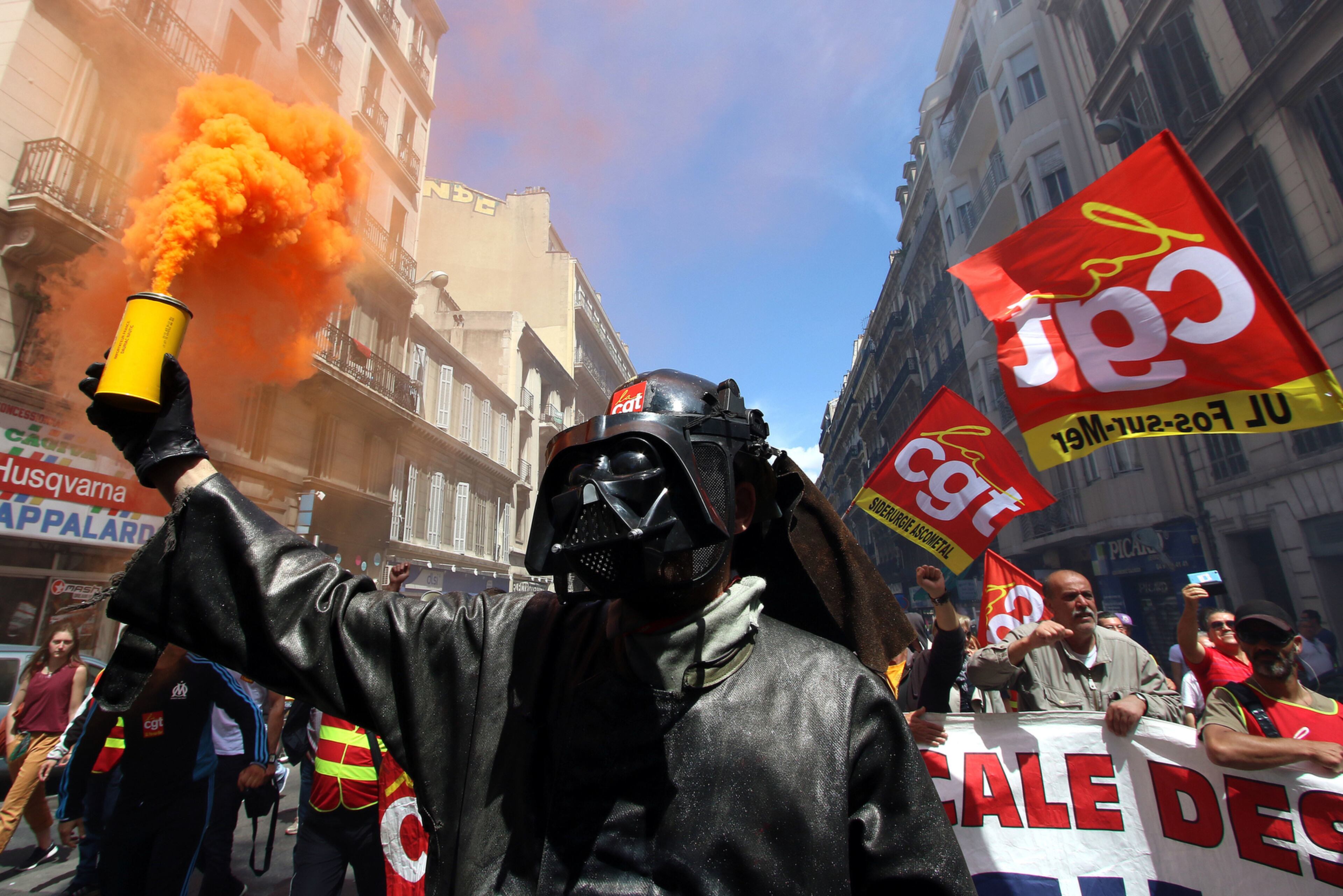 THE DARK SIDE STRIKES--A steelworker from the ArcelorMittal steel plant in Fos-sur-Mer wearing a mask of Darth Vader, burns flares during a demonstration in Marseille, southern France, Thursday, June 2, 2016. Several thousand protesters are demonstrating during a day of strikes and protest against the law job government reform. (AP Photo/Claude Paris)