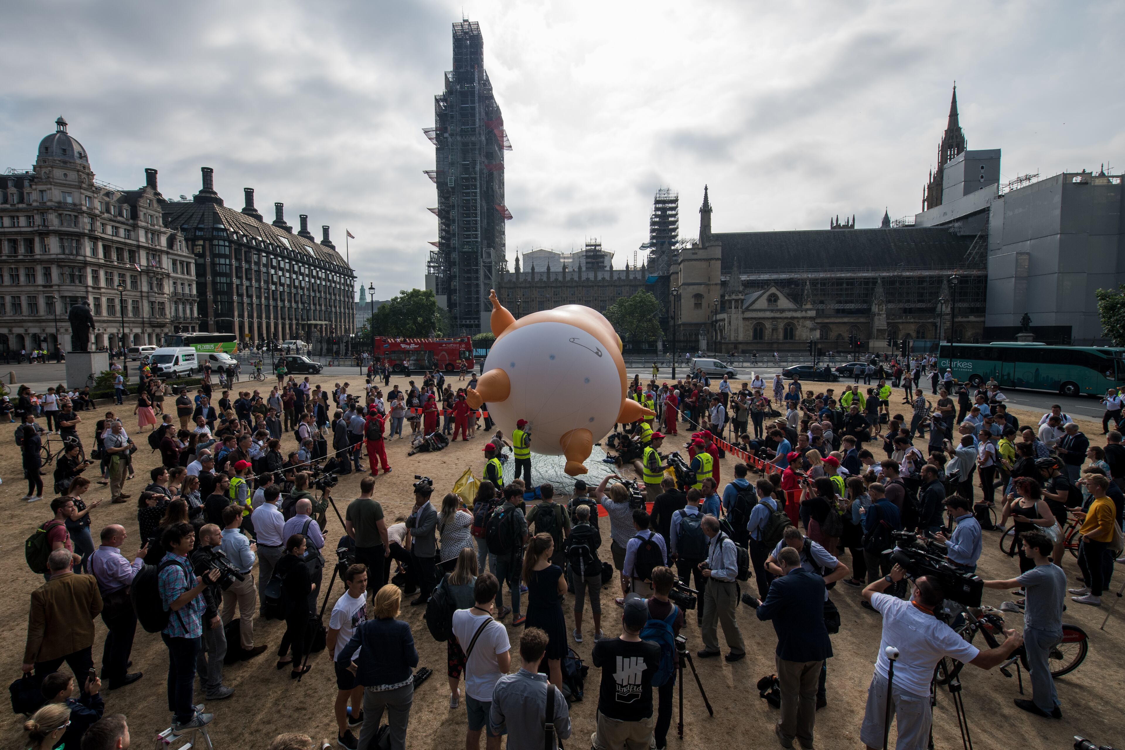 LONDON, UNITED KINGDOM - JULY 13: Demonstrators raise a six meter high effigy of Donald Trump, being dubbed the 'Trump Baby', in Parliament Square in protest against the U.S. President's current visit to the United Kingdom on July 13, 2018 in London, United Kingdom. The President of the United States and First Lady, Melania Trump, touched down yesterday in the UK on Air Force One for their first official visit. Today the President will visit Prime Minister Theresa May at Chequers and take tea with the Queen at Windsor Castle. (Photo by Chris J Ratcliffe/Getty Images)