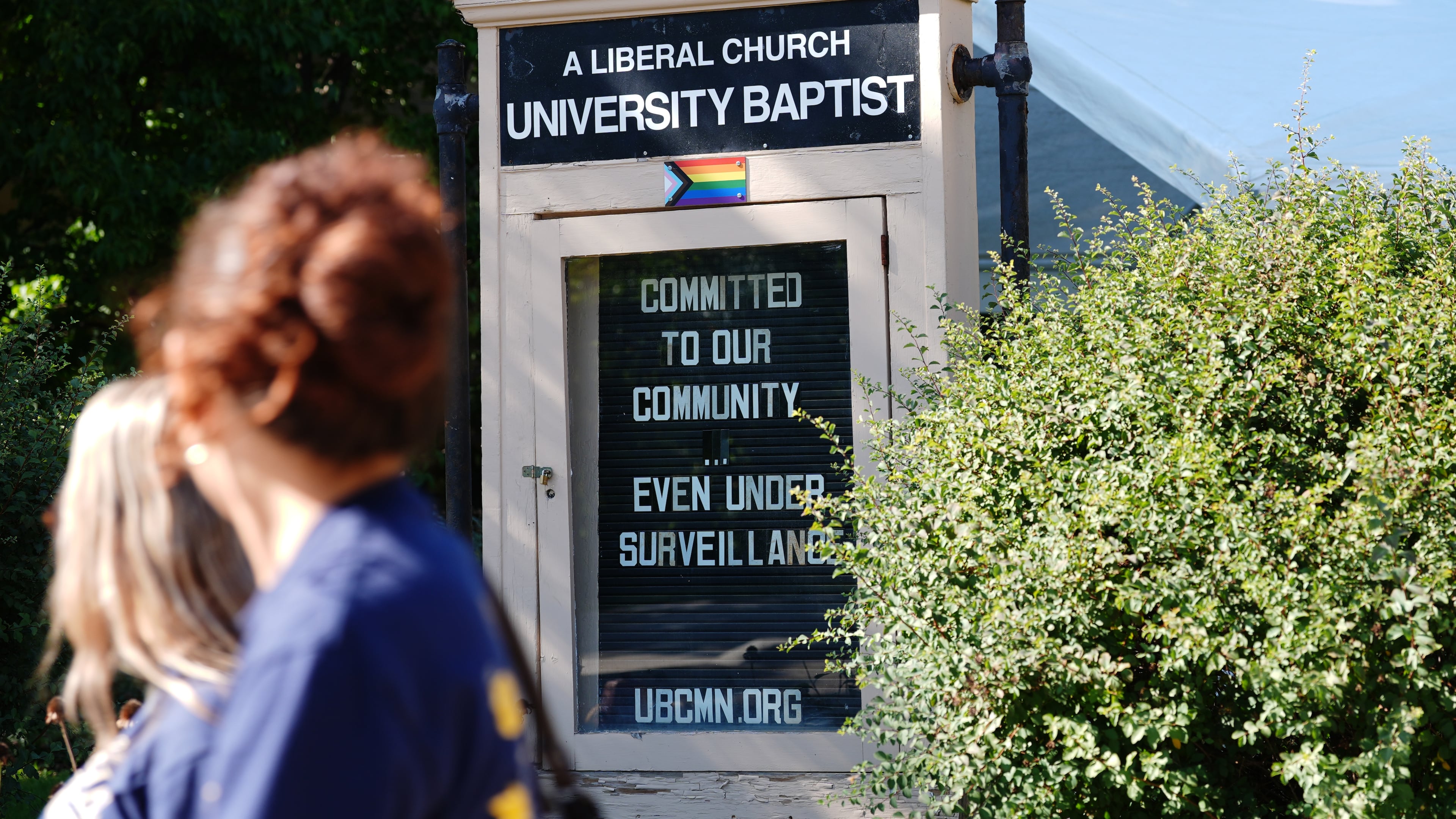 People walk by a sign outside University Baptist Church, Friday, Sept. 4, 2026, in Minneapolis. (AP Photo/Ellen Schmidt)