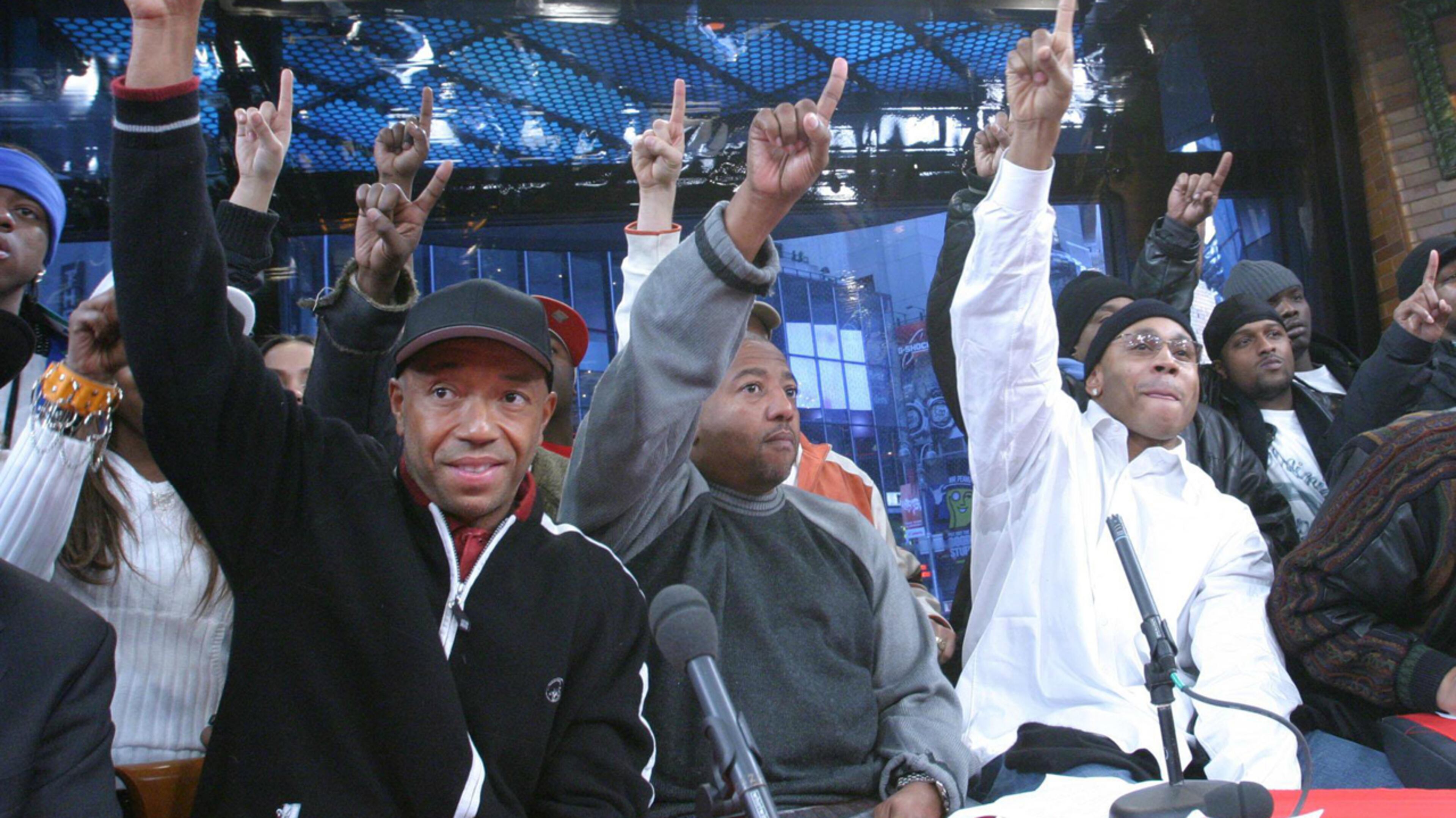 Hip-hop mogul Russell Simmons, left, Def Jam Records President Kevin Liles, center, and recording artist LL Cool J, foreground right, join others as they raise a single finger during the launch of the 'One Mind. One Vote.' campaign in New York, Monday, Jan. 19, 2004. Simmons endorsed Hillary Clinton for president Friday, saying she was a practical progressive he trusted while criticizing Sen. Bernie Sanders as “overstating what he can deliver to underserved communities.”