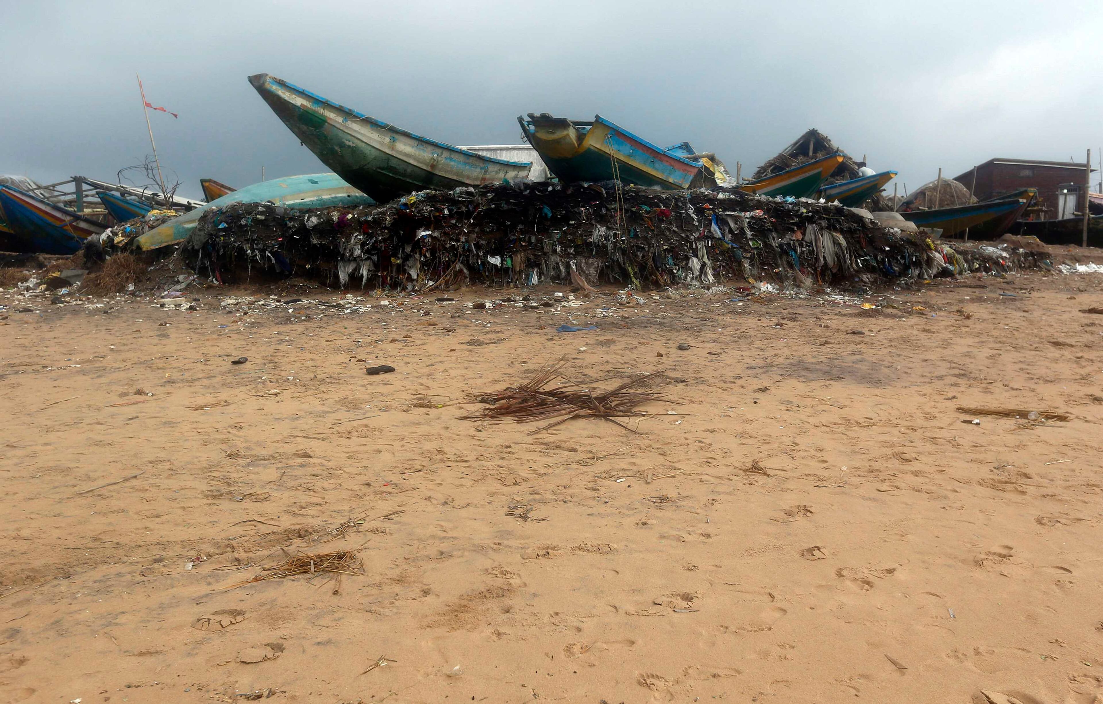 Boats are seen on an eroded shore after Cyclone Phailin hit Puri in the eastern Indian state of Odisha October 14, 2013. A mass evacuation saved thousands of people from India's fiercest cyclone in 14 years, but aid workers warned a million would need help after their homes and livelihoods were destroyed. Cyclone Phailin was expected to dissipate within 36 hours, losing momentum on Sunday as it headed inland after making landfall from the Bay of Bengal, bringing winds of more than 200 kph (125 mph) that ripped apart tens of thousands of thatched huts, mangled power lines and tore down trees. REUTERS/Ahmad Masood