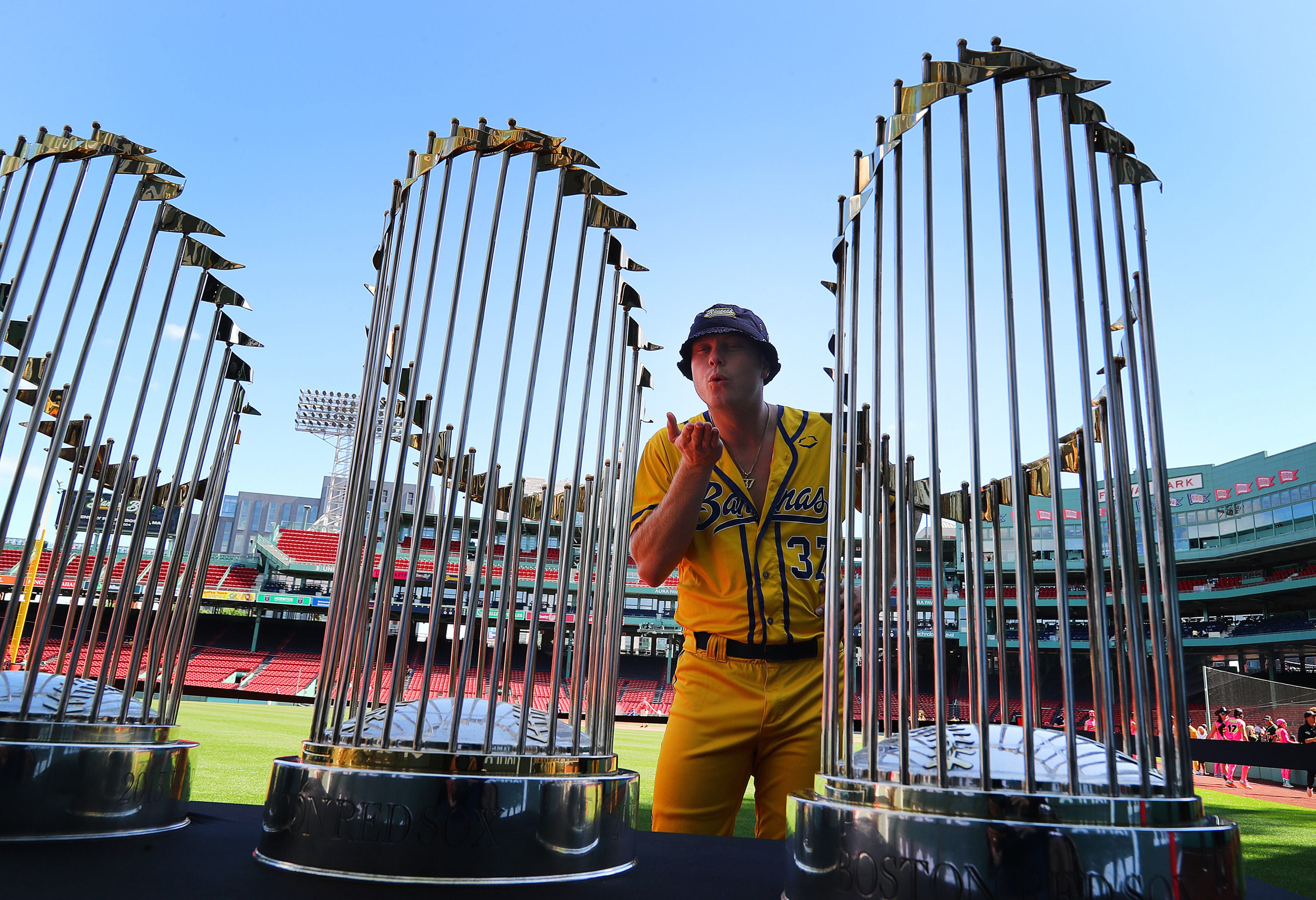 The Savannah Bananas took their World Tour to a sold-out Fenway Park on Saturday, June 8, 2024, as they played the Party Animals before over 37,000 fans in an entertaining take on traditional big league baseball. Bananas Ethan Skuija blows a kiss at the three Red Sox World Series trophies on display in the outfield. “How do we get one of these?” Skuija said as he chuckled. (John Tlumacki/Boston Globe)