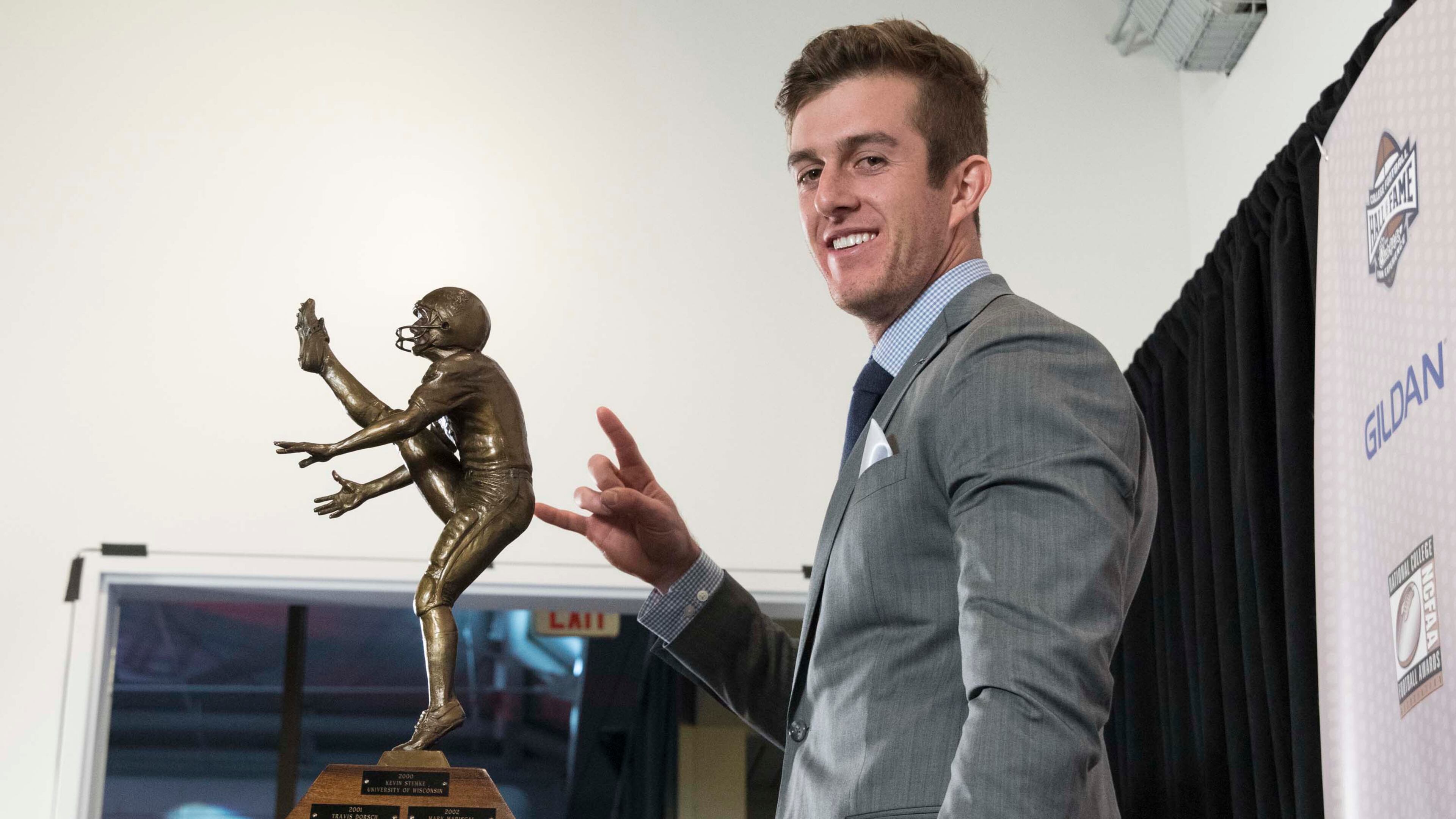 Texas' Michael Dickson, winner of the Ray Guy Award for outstanding punter, flashes "Hook 'em Horns" while posing with the trophy during the College Football Awards show at the College Football Hall of Fame, Thursday, Dec. 7, 2017, in Atlanta.