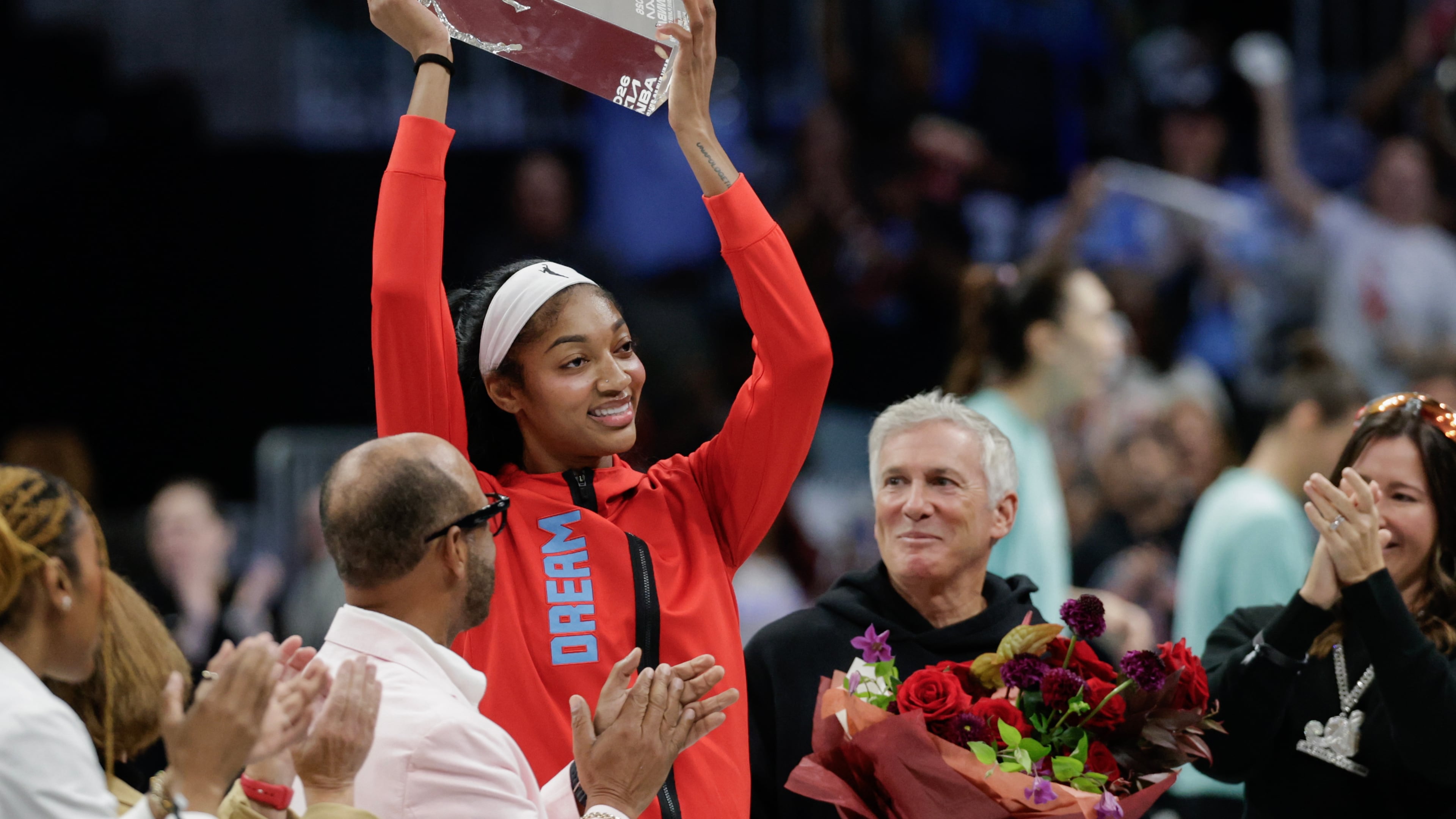 Atlanta Dream forward Angel Reese shows off her 2026 WNBA Defensive Player of the Year trophy before the tipofff a WNBA semifinal playoff Game 1 between the Atlanta Dream and the New York Liberty, Sunday, Oct. 4, 2026, in Atlanta. (Erik S. Lesser for the AJC)