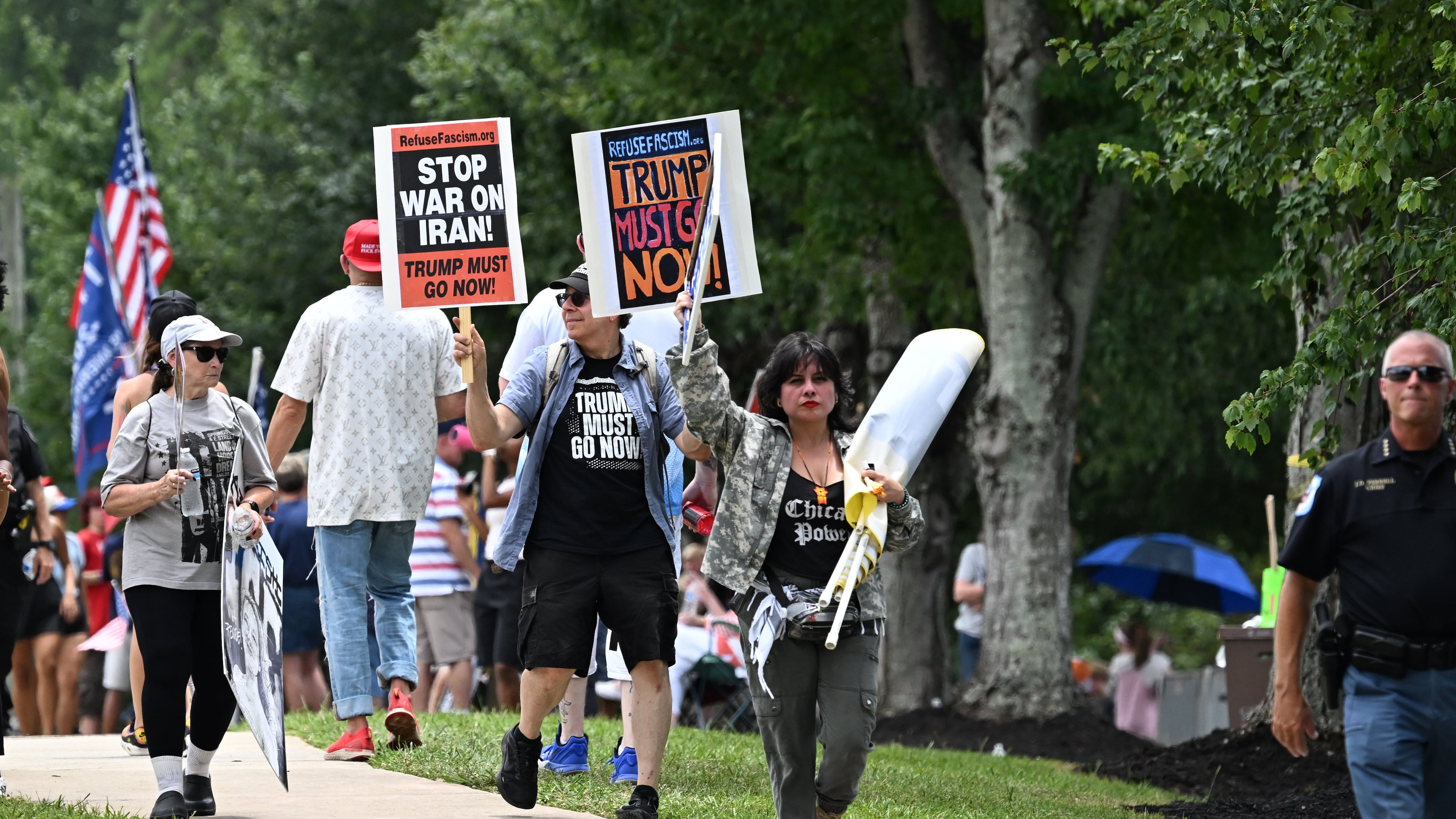 Protesters opposed to President Donald Trump's visit hold signs and line a street as he arrives outside Wheeler High School on Wednesday, July 22, 2026, in Marietta. President Donald Trump is visiting Cobb County’s Wheeler High School on Wednesday to promote a new investment account for children. (Hyosub Shin/AJC)