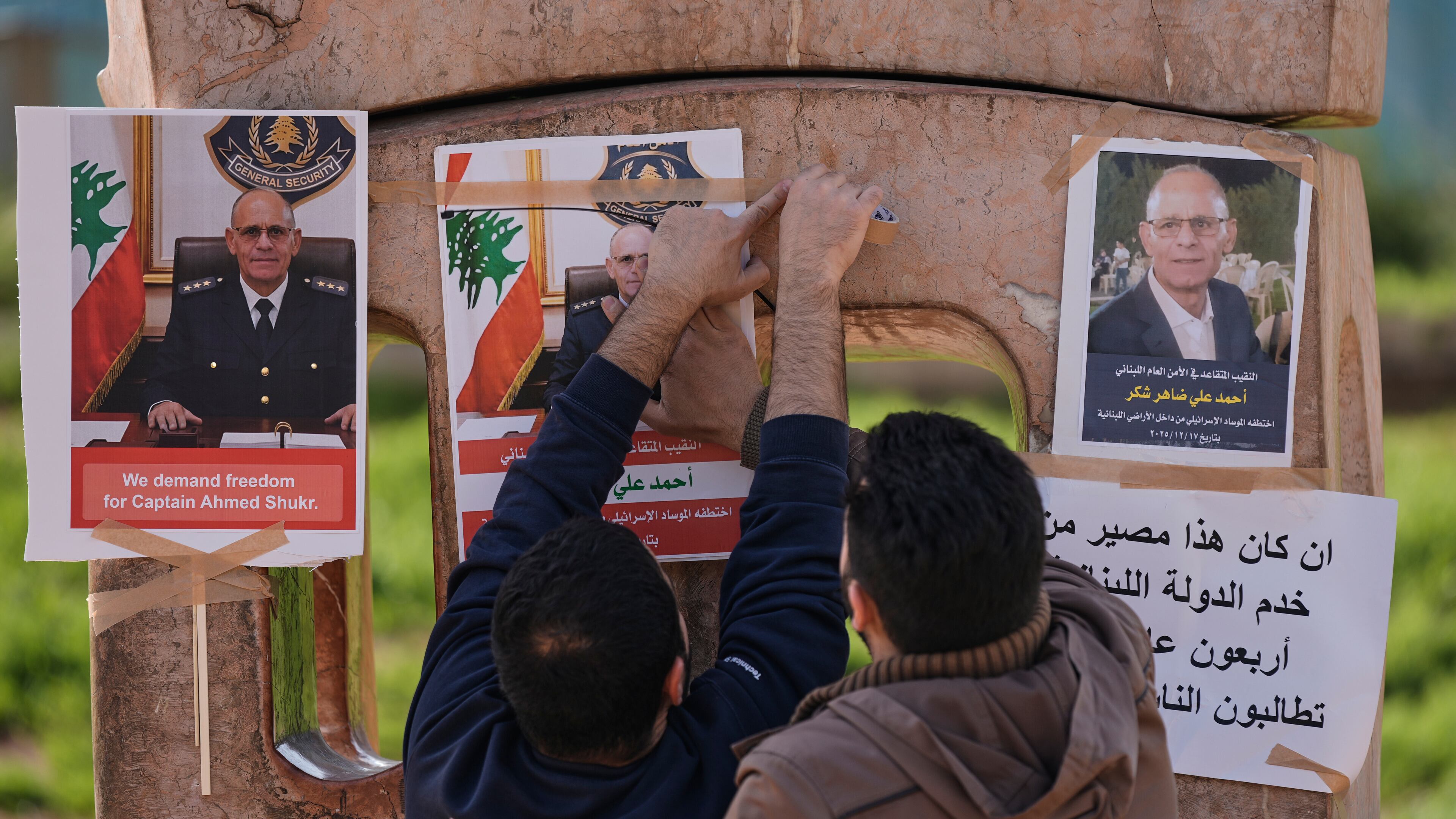 Family members of retired Lebanese officer Ahmed Shukr, hang posters of him during a gathering outside the headquarters of the U.N. Economic and Social Commission for Western Asia, ESCWA, in Beirut, Lebanon, Friday, Feb. 13, 2026. (AP Photo/Bilal Hussein)