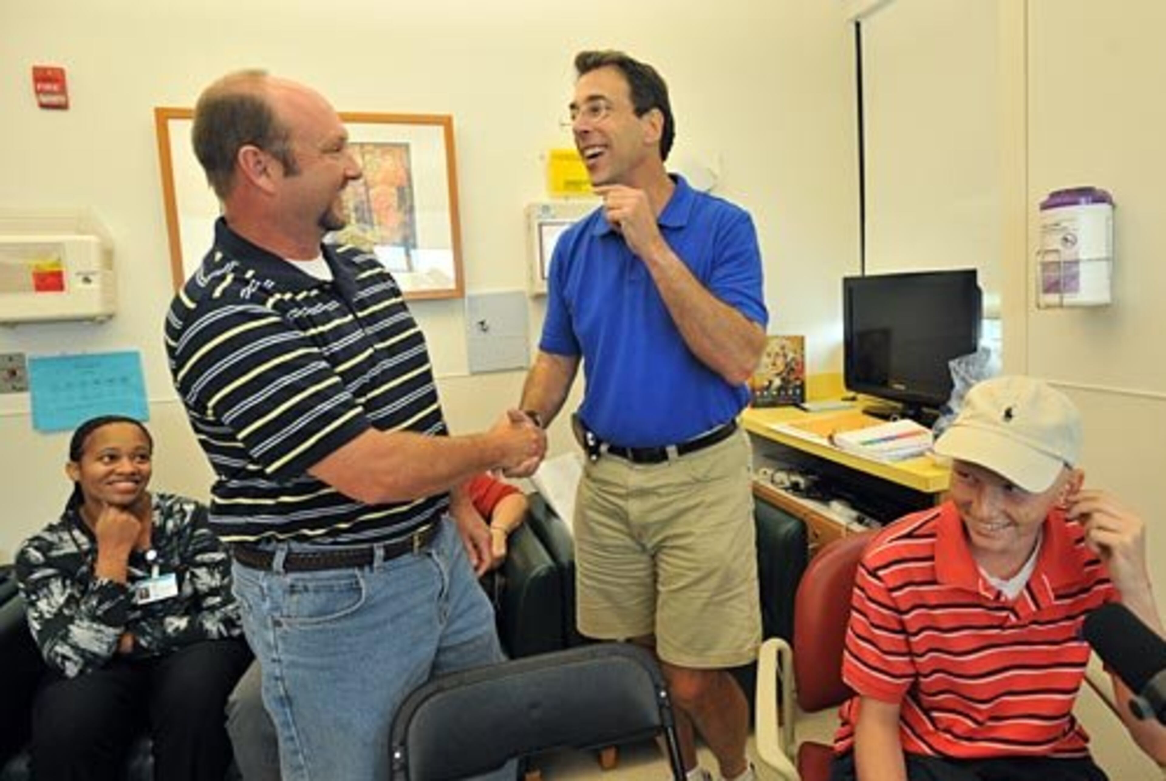 Clark Howard (third from left) talks with Stuart Dobson of Marietta as Dobson's son, Christopher (right), looks on.