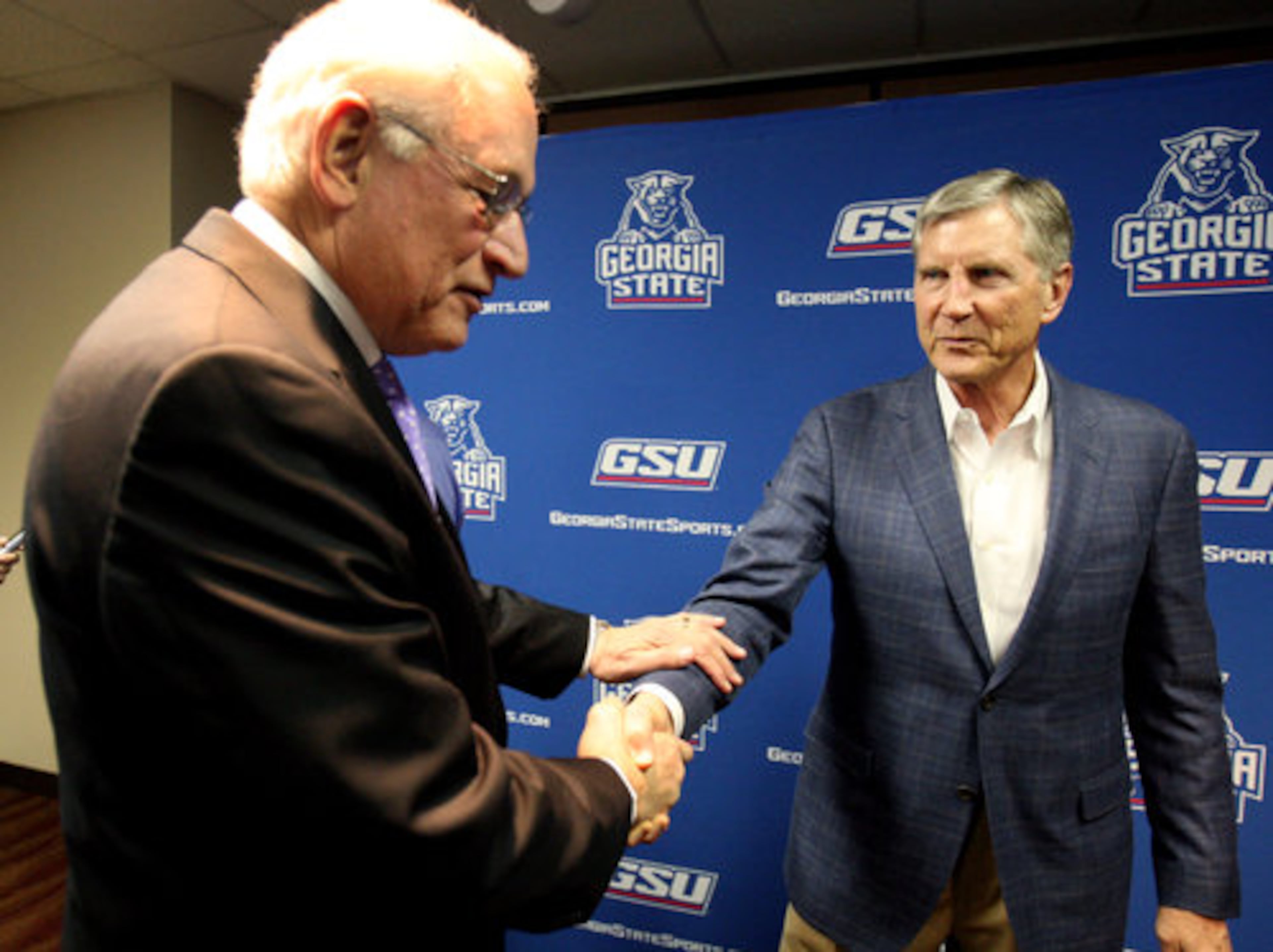 Sun Belt Conference president and Troy University chancellor Jack Hawkins, left, greets Georgia State University football coach Bill Curry after GSU announced plans to join the Sun Belt Conference in 2013 at the Georgia Dome Monday afternoon in Atlanta, Ga., April 9, 2012.