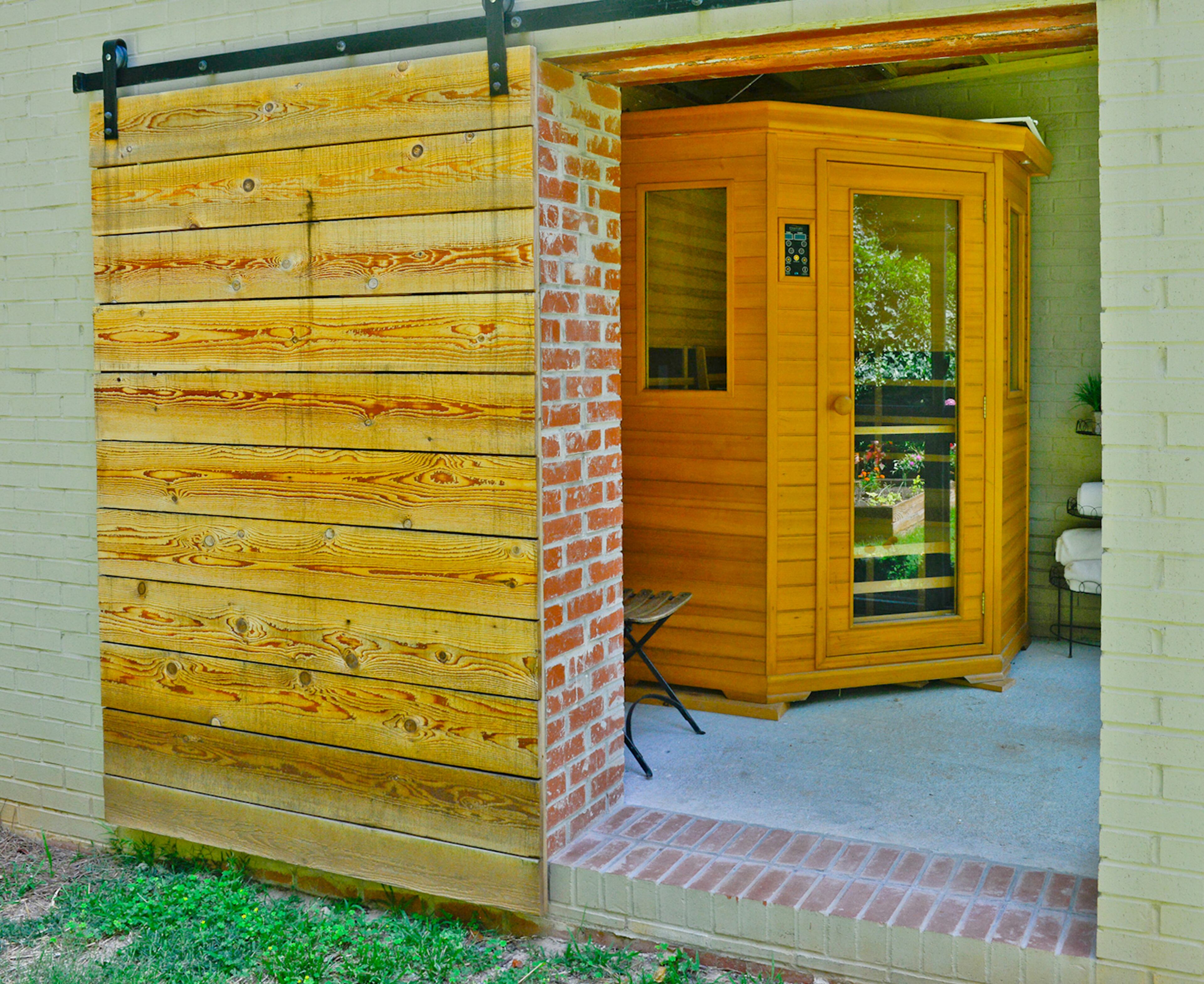 Finny Moore built this infrared sauna to sweat out toxins and stay healthy. The painted brick exterior makes the structure look like it was part of the Atlanta home while a sliding barn door keeps that look casual.