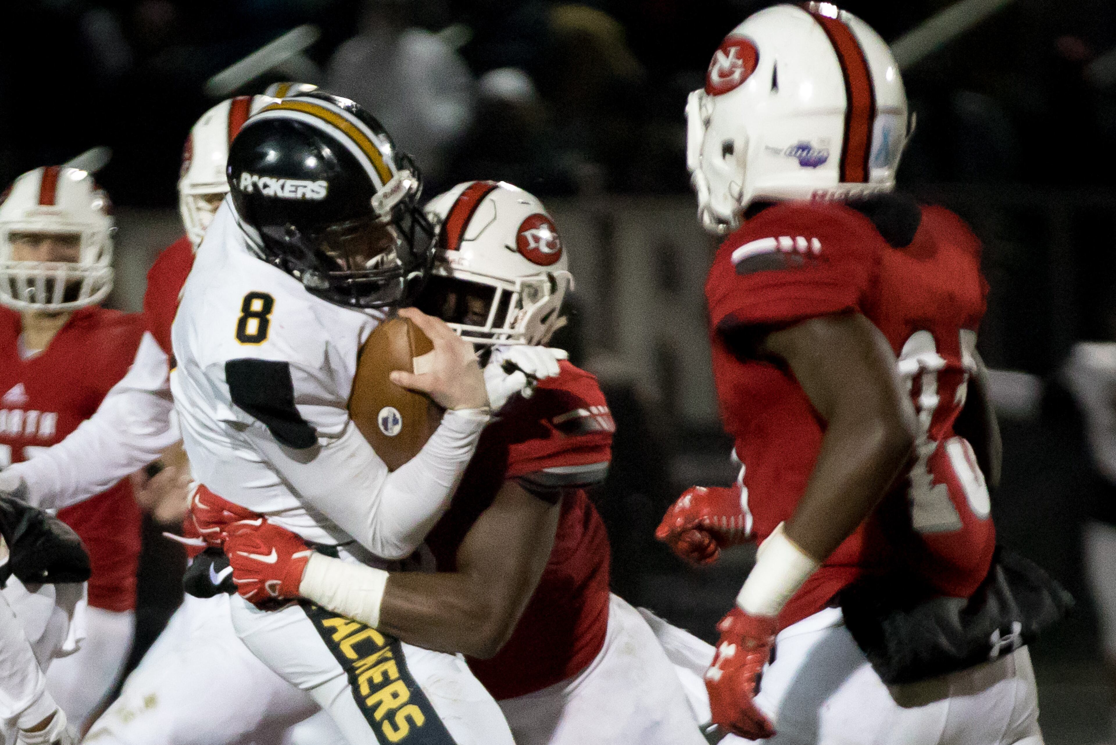 Colquitt County quarterback Steven Krajewski (8) is tackled by North Gwinnett High School's Jayden Mcdonald (8) during a Class AAAAAAA football championship game, Friday, Dec. 15, 2017, in Suwanee, Ga.
