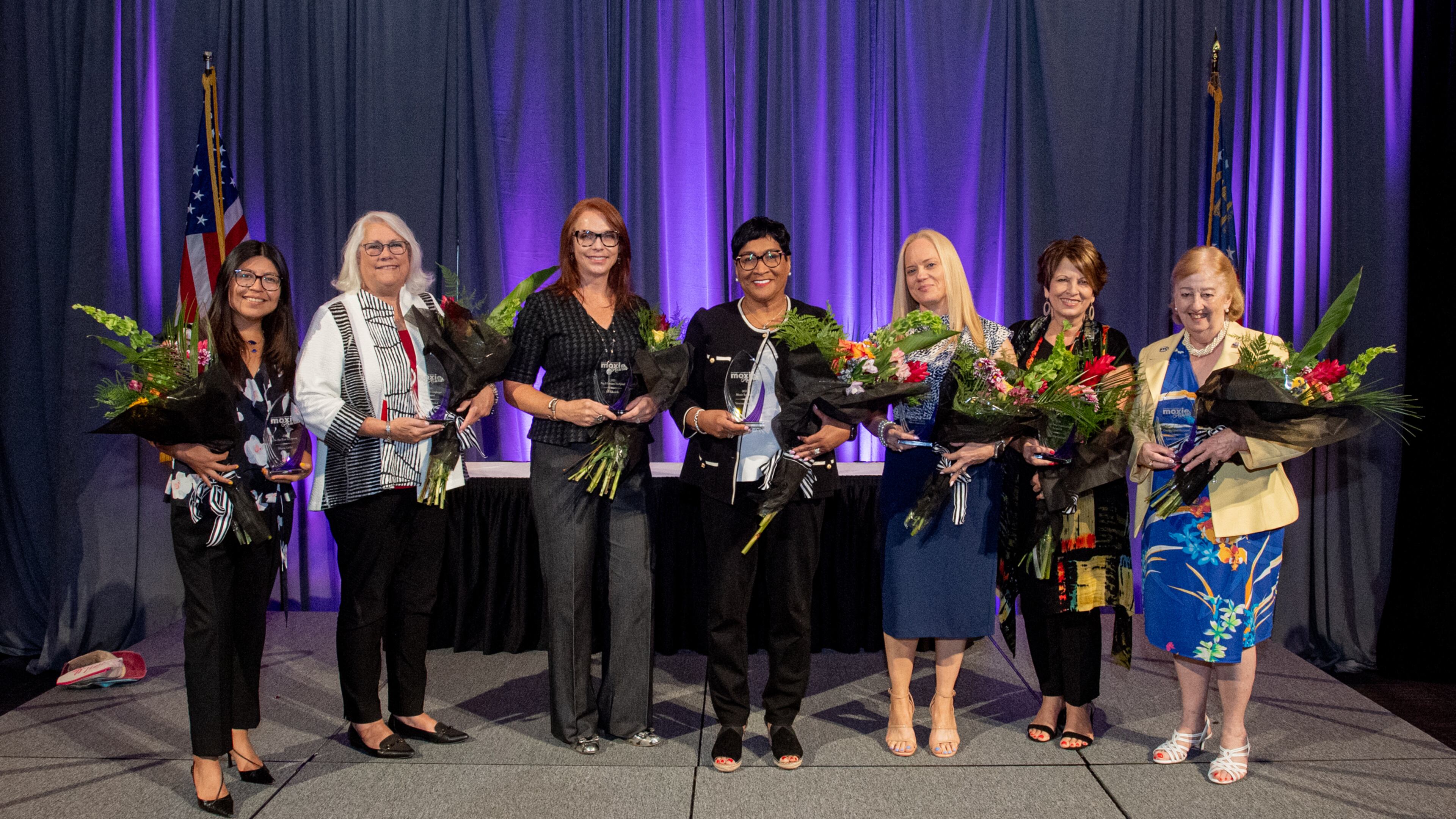 Gwinnett Chamber 2021 Moxie Award winners from l-r: Maria Uribe, Junior Achievement of Georgia, On the Rise Award; Debbie Smith representing Georgia United Credit Union; Jill Edwards, United Community Bank, Pay It Forward Award; Venessa Harrison, AT&T Moxie Award; Major Michelle Anglin, Gwinnett County Police Department, Influence Award; Lisa Zaken representing Leadership Gwinnett; and Lorri Christopher, City of Peachtree Corners, Greater Good Award.