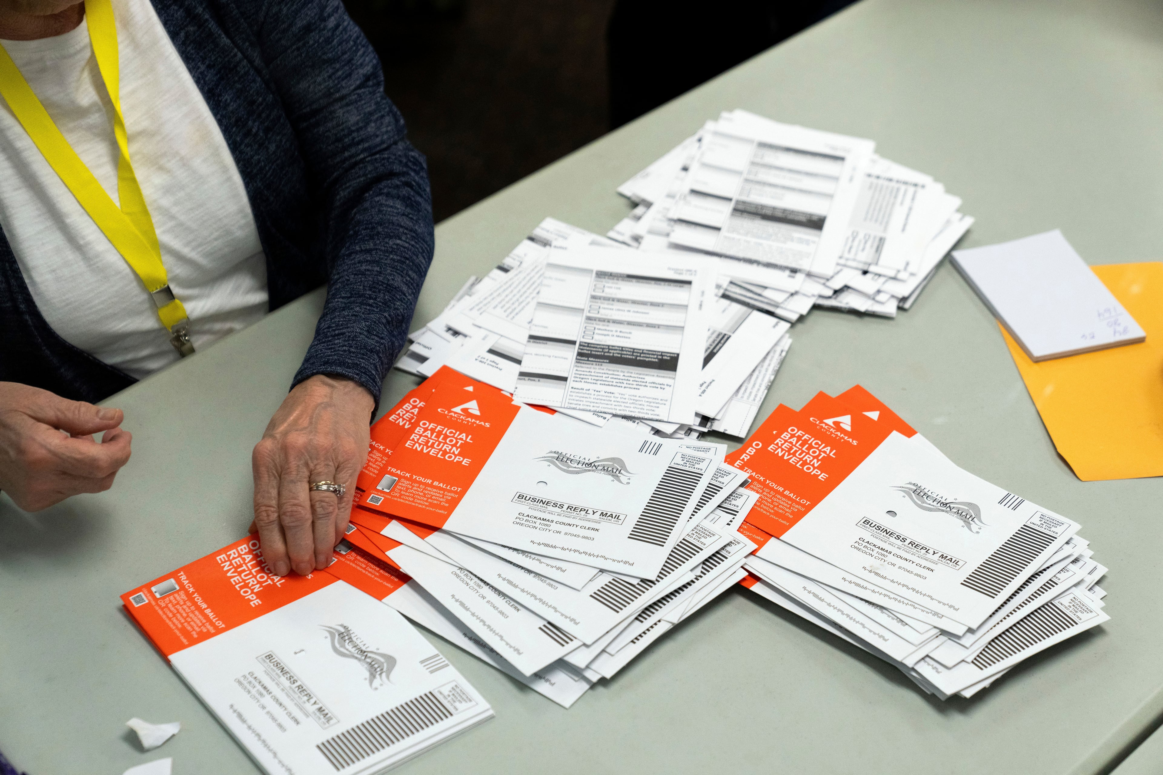 An election worker reaches for an unopened ballot during sorting in Oregon in 2024. (Jenny Kane/AP)