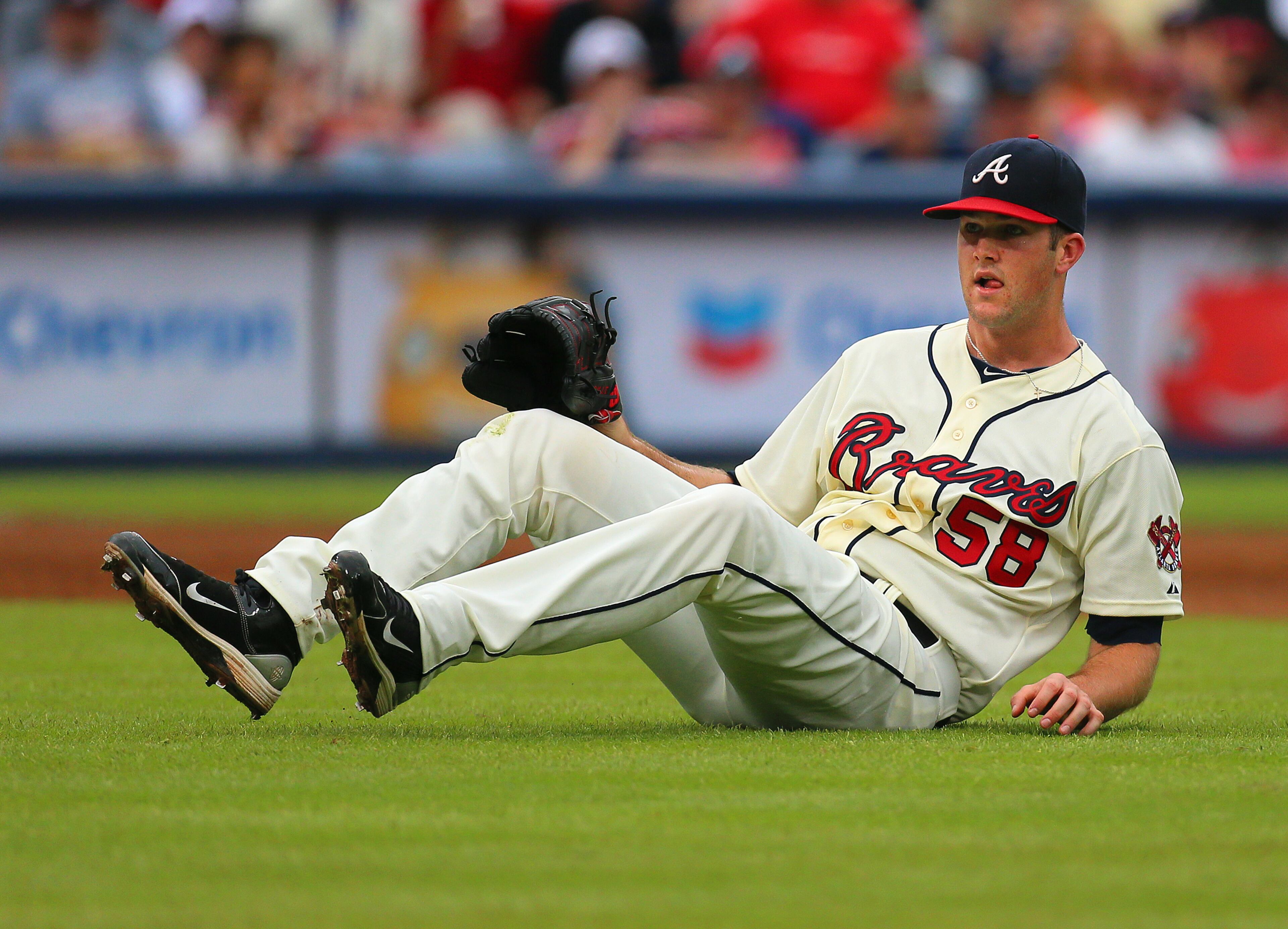 Braves pitcher Alex Wood hits the ground on a ground ball by Marlins Giancarlo Stanton to short stop Andrelton Simmons during the second inning in their MLB baseball game on Sunday, Sept. 1, 2013, in Atlanta. Woods was pulled in the third inning trailing the Marlins 7-0.