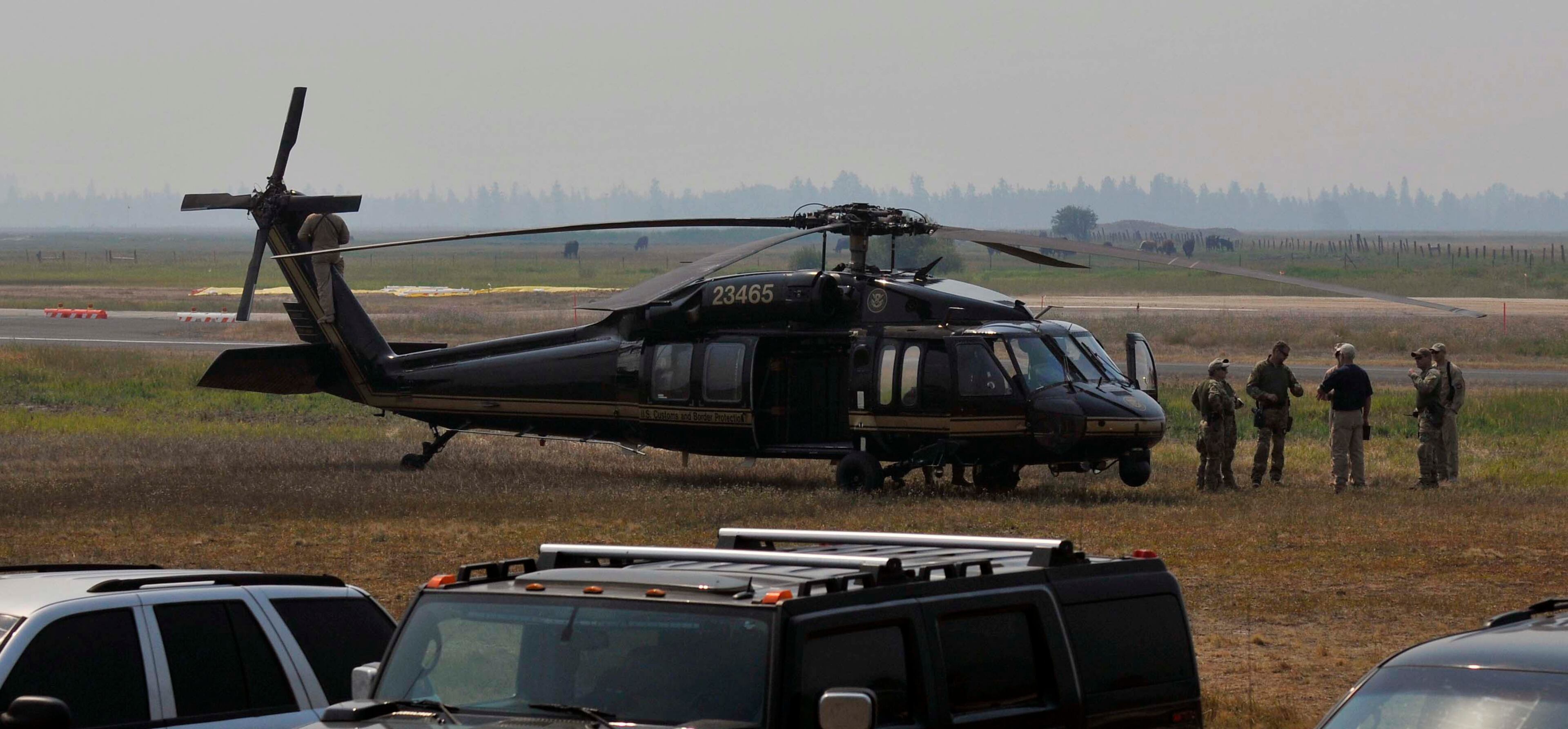Authorities wait near a blackhawk helicopter at the Cascade Airport in Cascade, Idaho, Saturday, Aug. 10, 2013. About 150 federal agents have converged on Idaho's Frank Church River of No Return Wilderness in the search for 16-year-old Hannah Anderson and her suspected abductor, 40-year-old James Lee DiMaggio. (AP Photo/Robby Milo)