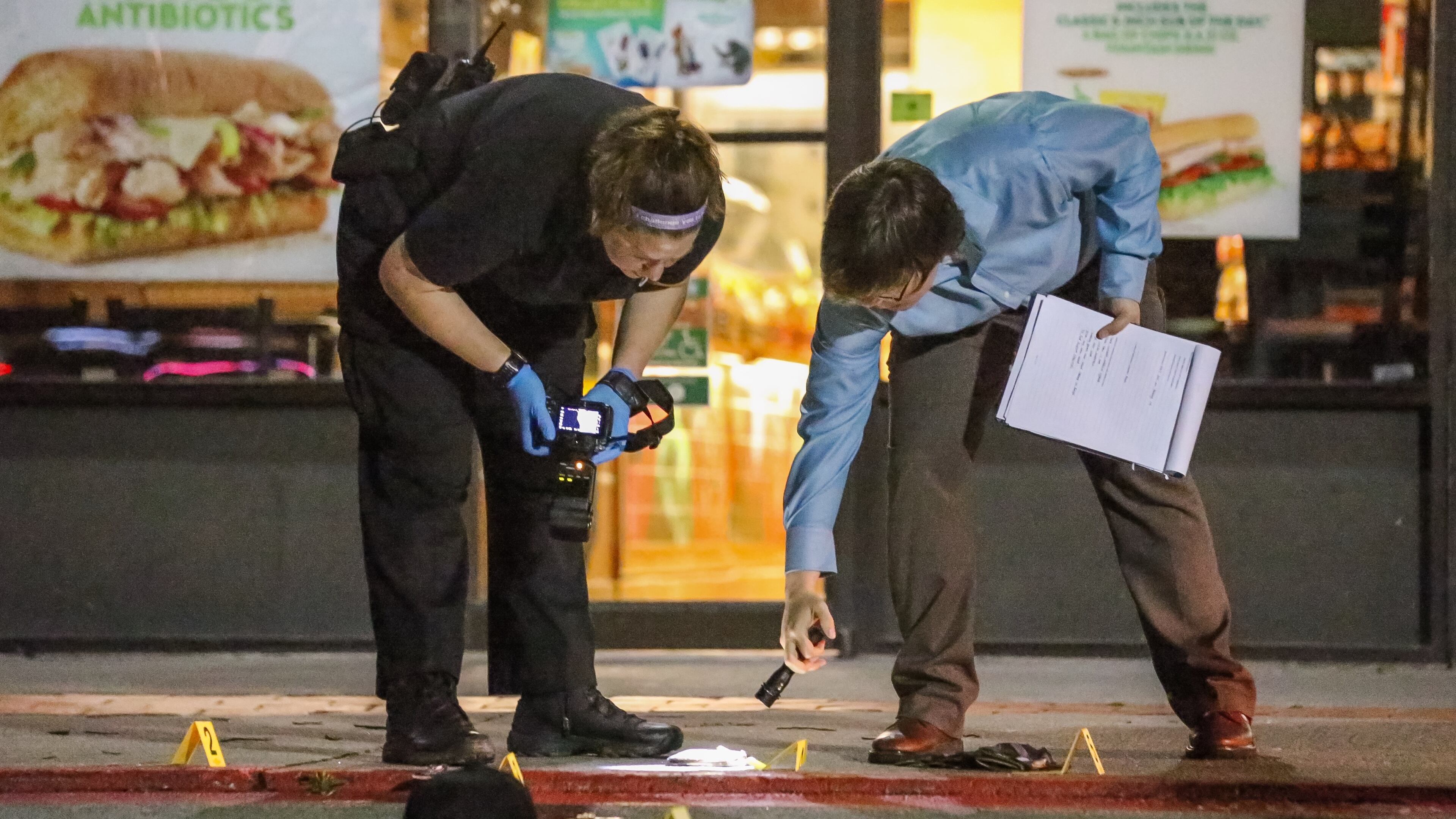 Law enforcement officials investigate a shooting at a DeKalb County shopping center Fri., March 11, 2016. JOHN SPINK / JSPINK@AJC.COM
