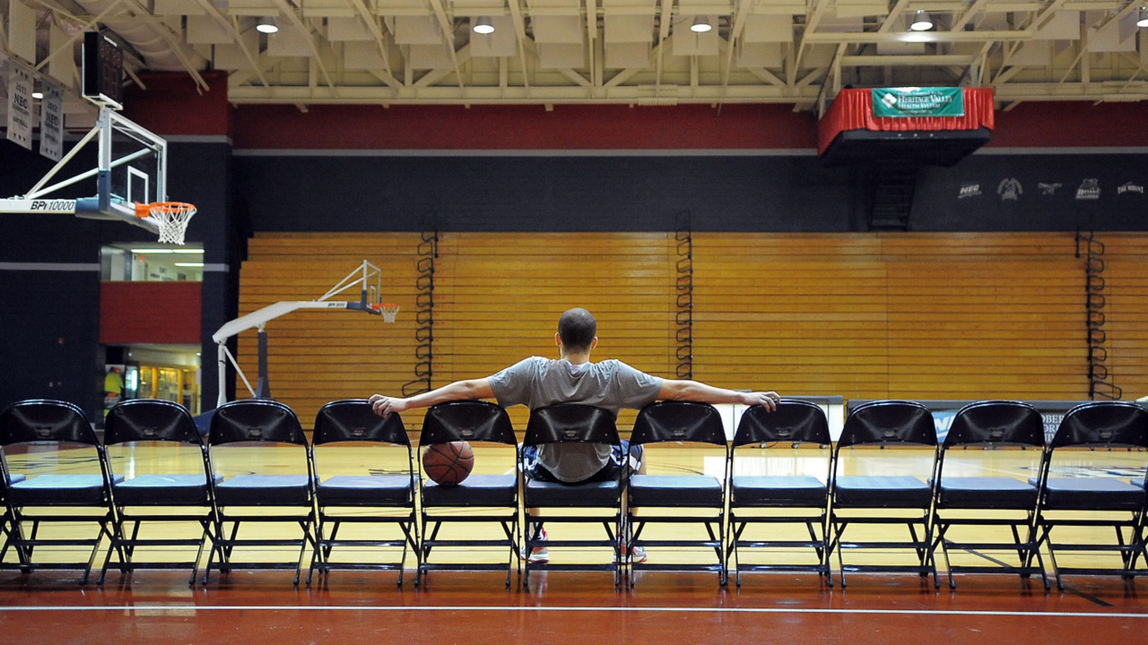 Robin Rombach/Post-Gazette - March 18, 2013 - Moon Twp. - local/sports - Calm before the Madness - -Robert Morris University basketball player Shane Sweigart, a 5th year senior, relaxes in the quiet of the empty gym before the team's practice on Monday. The Colonials will host the University of Kentucky on Tuesday in the NIT tournament. PUBLISHED CAPTION: Robin Rombach/Post-GazetteCalm before the MadnessRobert Morris University basketball player Shane Sweigart relaxes in the quiet of the empty gym before the teams practice on Monday. The Colonials will host the University of Kentucky on Tuesday in the NIT tournament. Robin Rombach/Post-GazetteLOTS of seatsat RMU,for now Robert Morris University basketball player Shane Sweigart relaxes in the quiet of an empty gym before the teams practice on Monday. The Colonials will host the University of Kentucky today in the NIT tournament.Story, B-1. Original Filename: 318RMU2.jpg