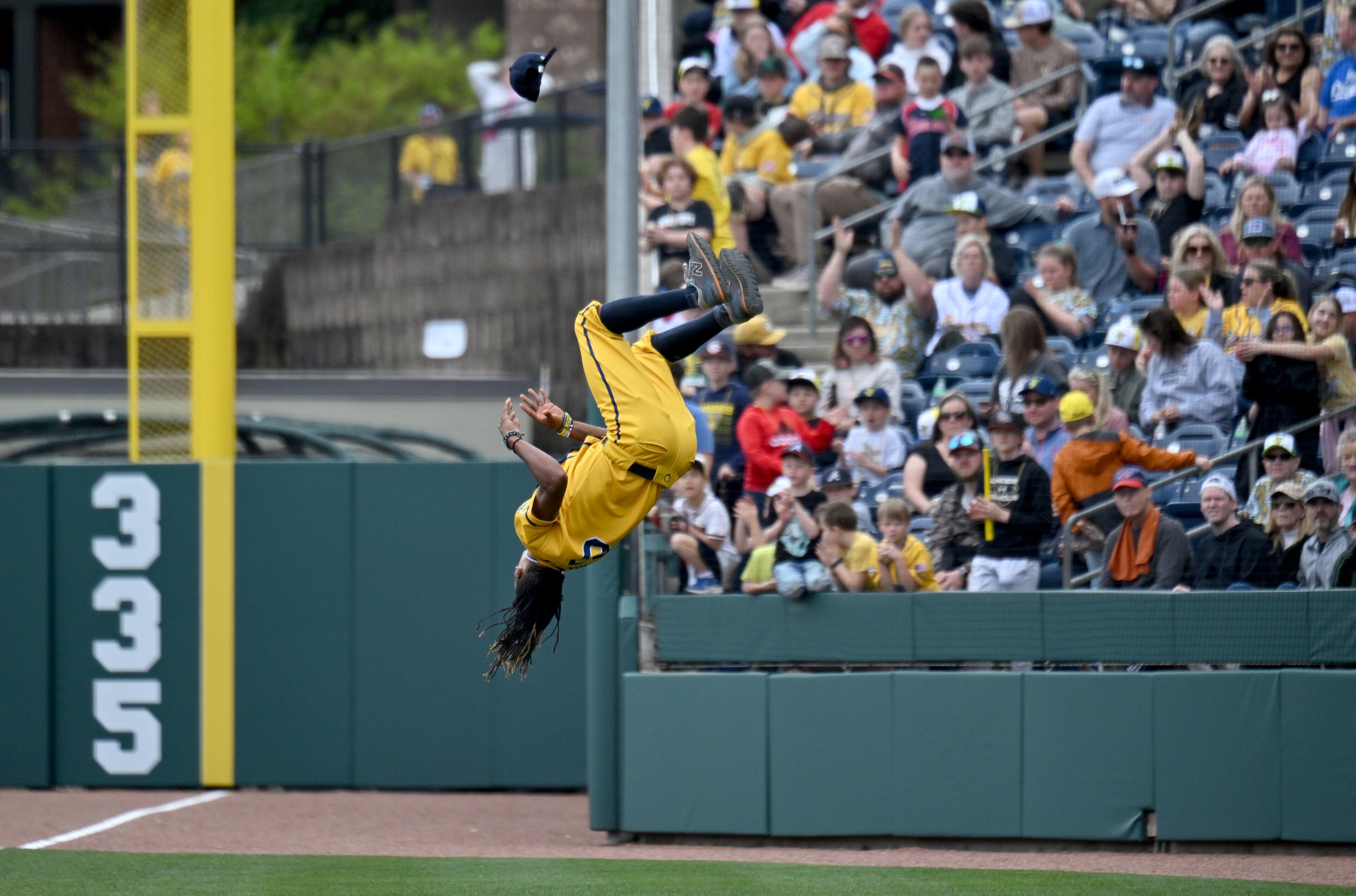 Savannah Bananas first-base coach Maceo Harrison does a flip. (Hyosub Shin / Hyosub.Shin@ajc.com)