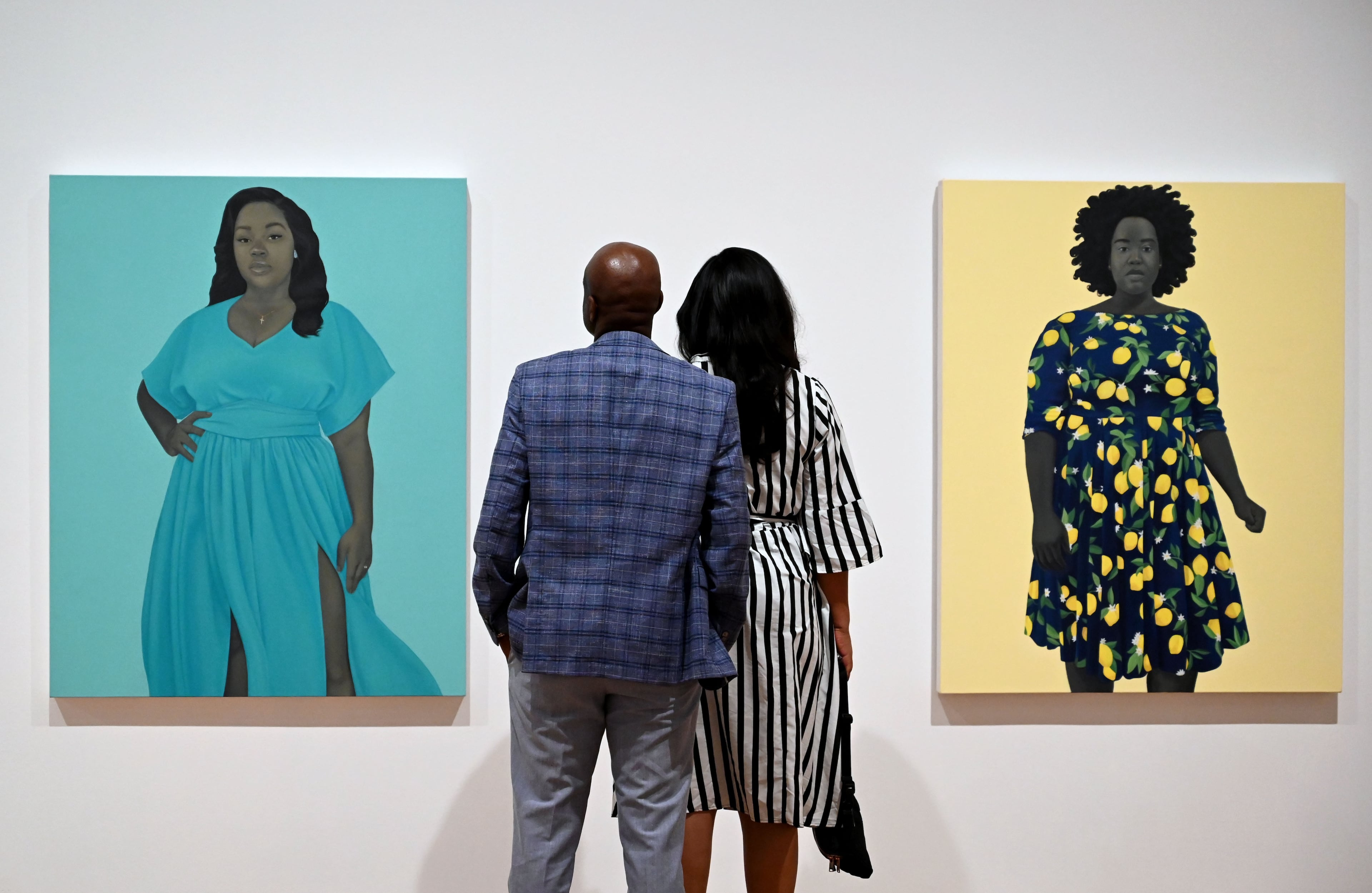 Visitors look at “Breonna Taylor” (left) and “She Always Believed the Good about Those She Loved” in the “American Sublime” exhibition at the High Museum of Art on Friday, May 15, 2026, in Atlanta. The latter painting features the model who stood in to pose for the portrait of the late Breonna Taylor. (Hyosub Shin/AJC)
