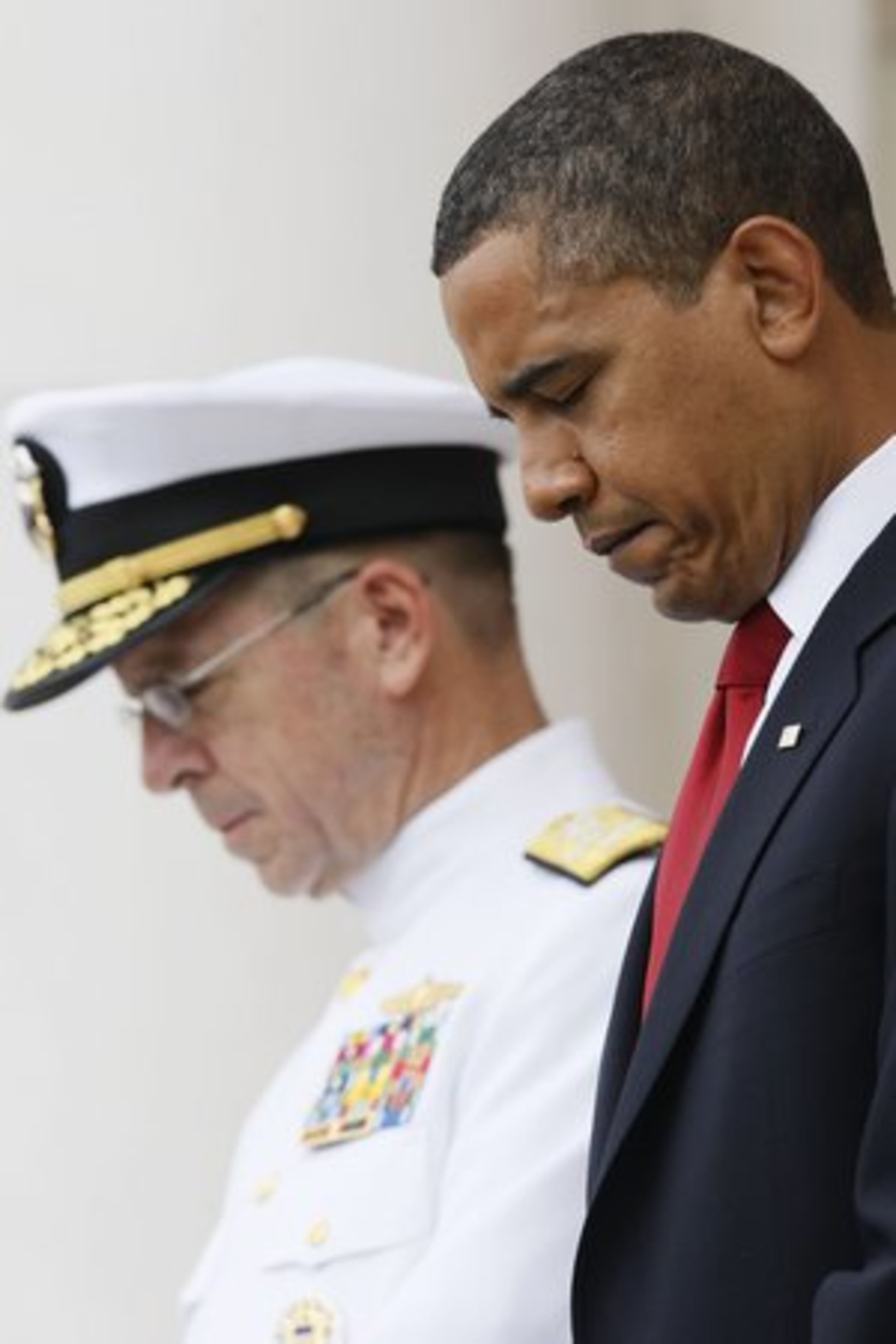 President Barack Obama and Adm. Mullens, bow their heads during the invocation.