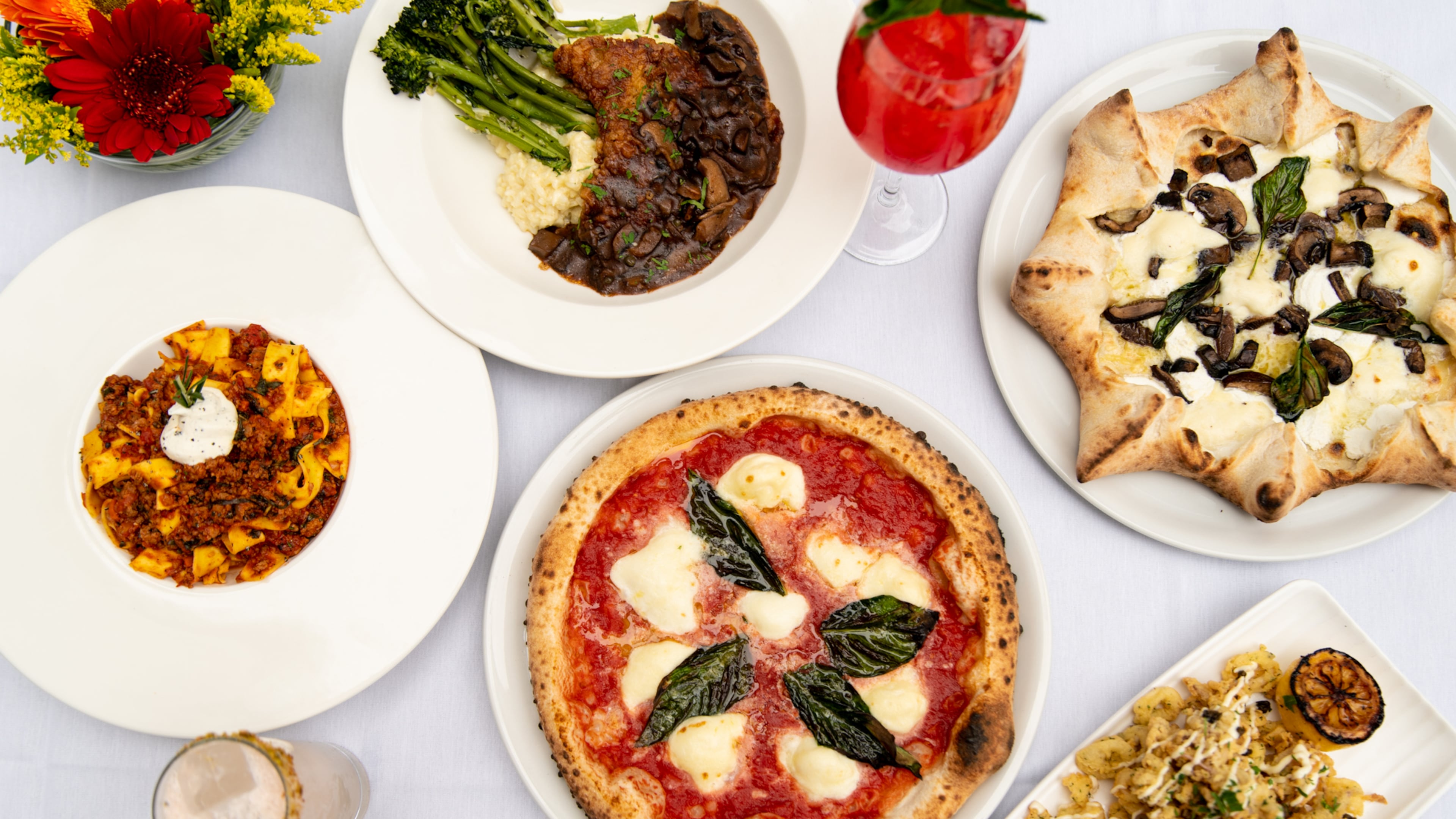 Amalfi Cucina & Mercato is now open in Buckhead, with a menu including (clockwise, from left) Veal Bolognese, Veal Marsala, Tartufo E Funghi Carnevale Pizza, Calamaio, and (center) Amalfi Margherita D.O.P. Pizza. Also shown are cocktails called The Spritz (upper right) and Franco's Fizz (lower left). (Mia Yakel for The Atlanta Journal-Constitution)