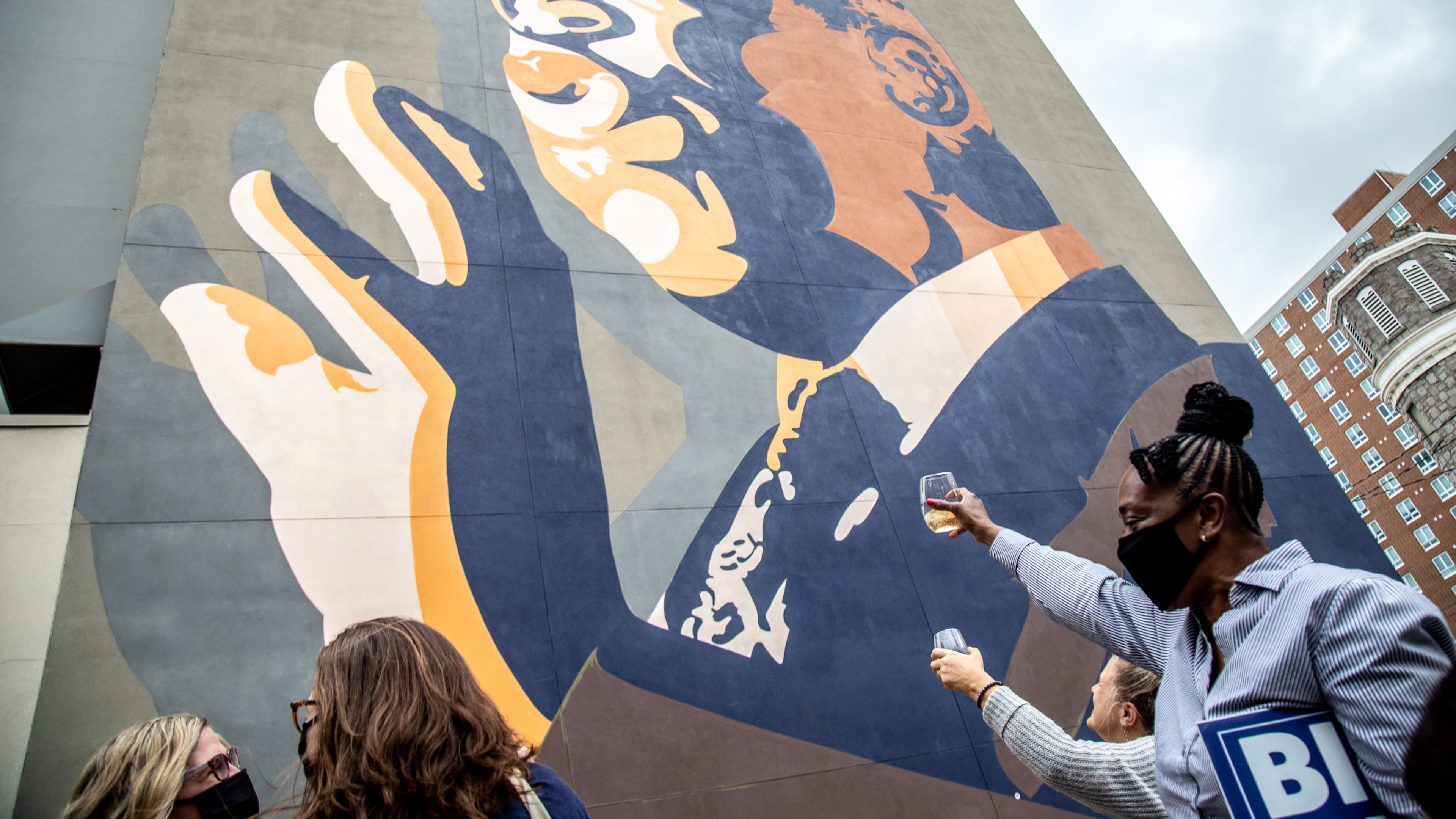 People raise a glass of champagne to the John Lewis mural after the election was called for Joe Biden Saturday, November 7, 2020. STEVE SCHAEFER / SPECIAL TO THE AJC