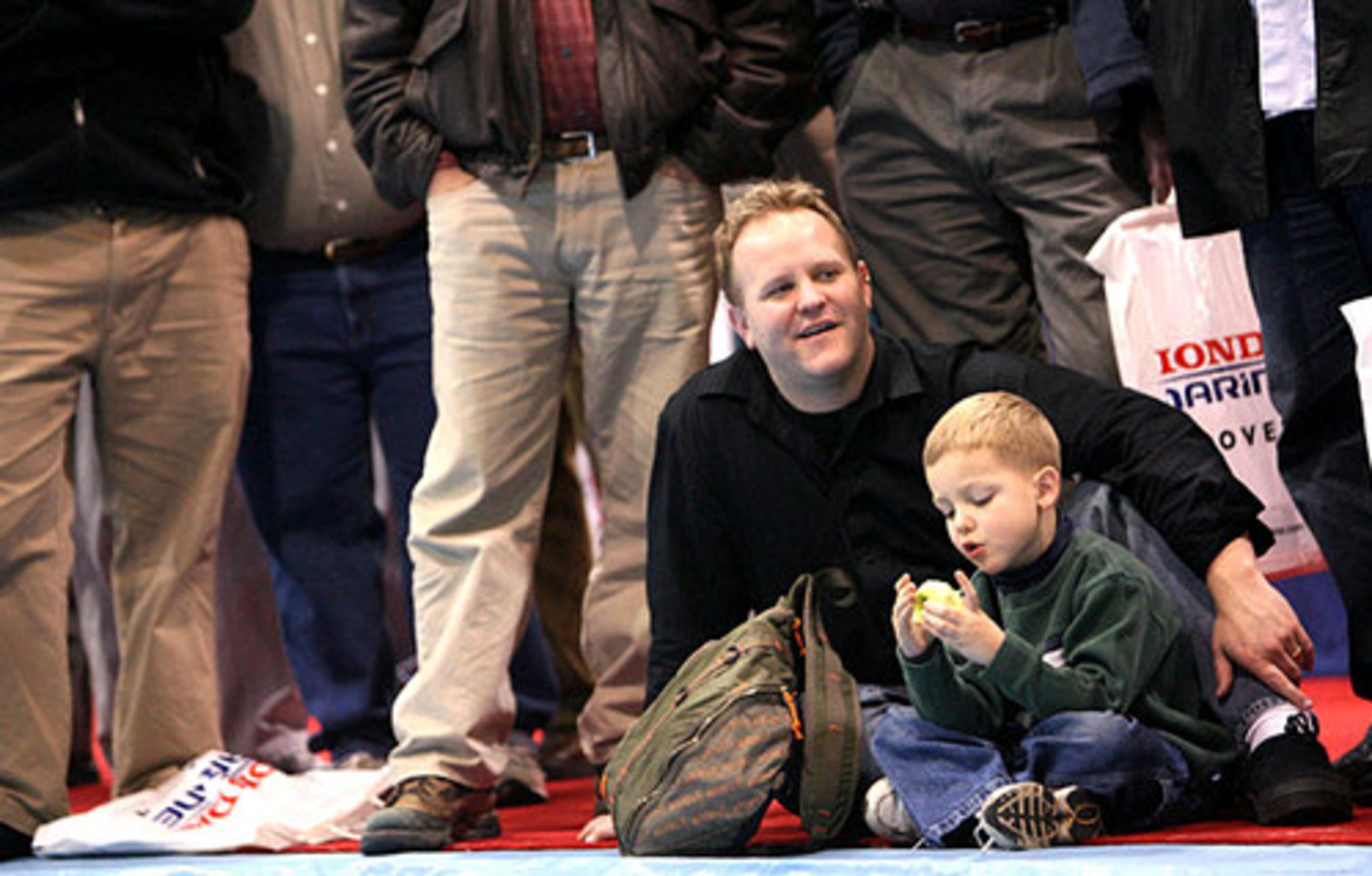 Corey Vander Veen, of Woodstock, sits with his son Liam, 6, as he listens to Fly Fishing legend Bernard "Lefty" Kreh during a demonstration.