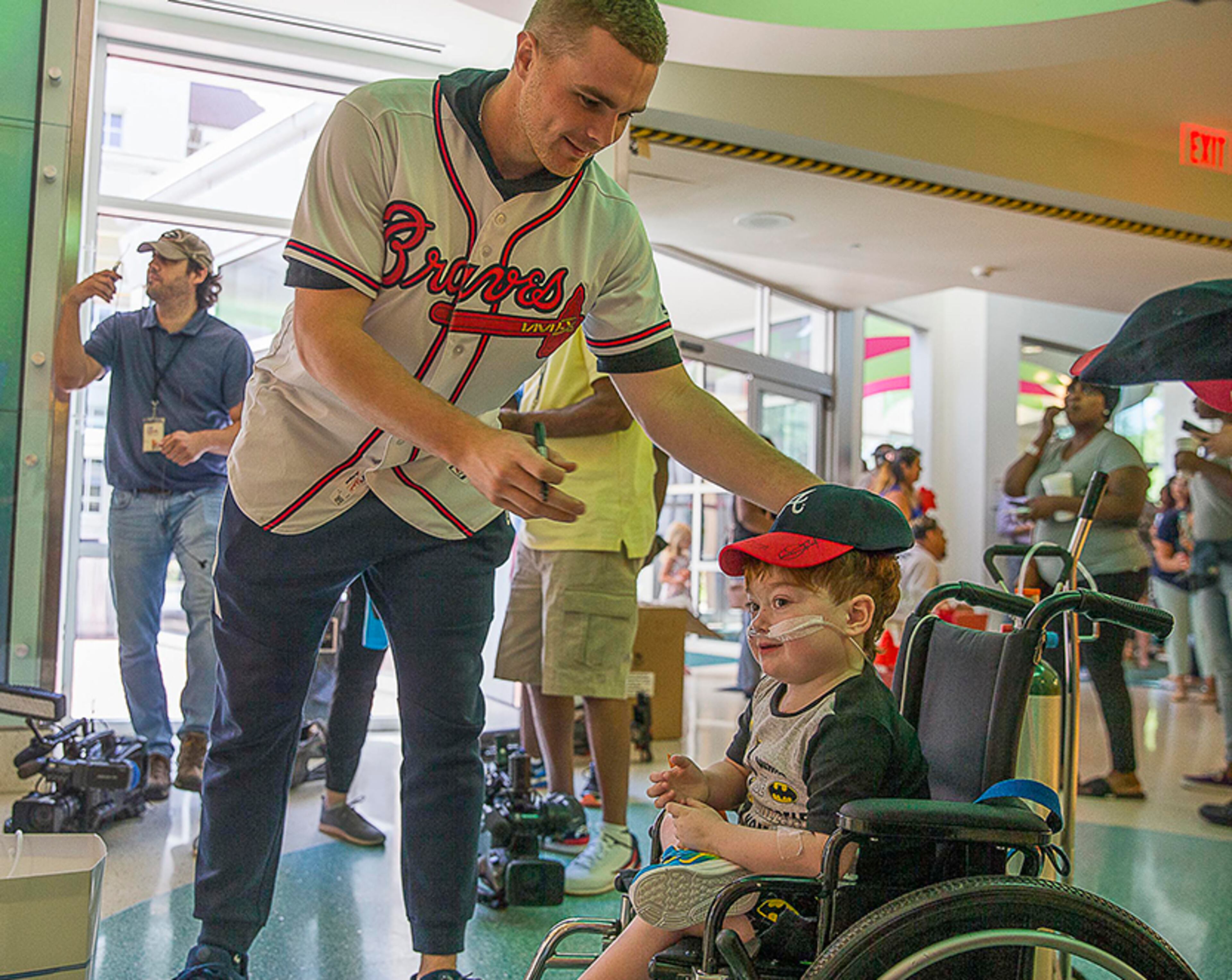 Braves pitcher Sean Newcomb places a baseball cap on Branley Palmer's head after signing the memorabilia during the team's visit Tuesday, May 28, 2019, to the Children's Healthcare of Atlanta at Egleston Hospital. Players met with kids and signed autographs and performed arts and crafts projects during the visit.