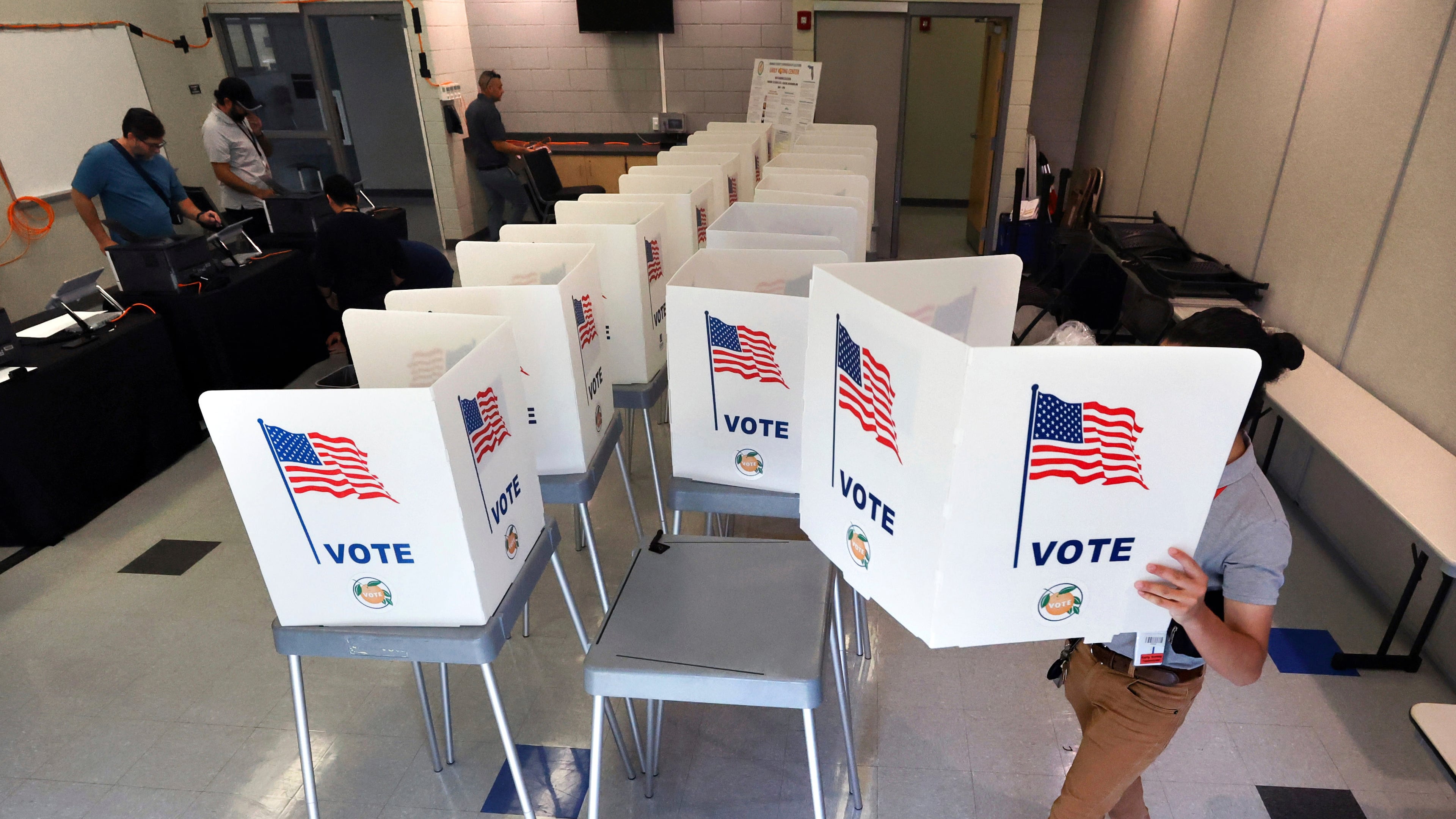 FILE - Lenny Carrillo, from the Orange County Supervisor of Elections Office, sets up voting booths at the Meadow Woods Community Center in Orlando, Fla., Oct. 15, 2024. (Joe Burbank/Orlando Sentinel via AP, File)