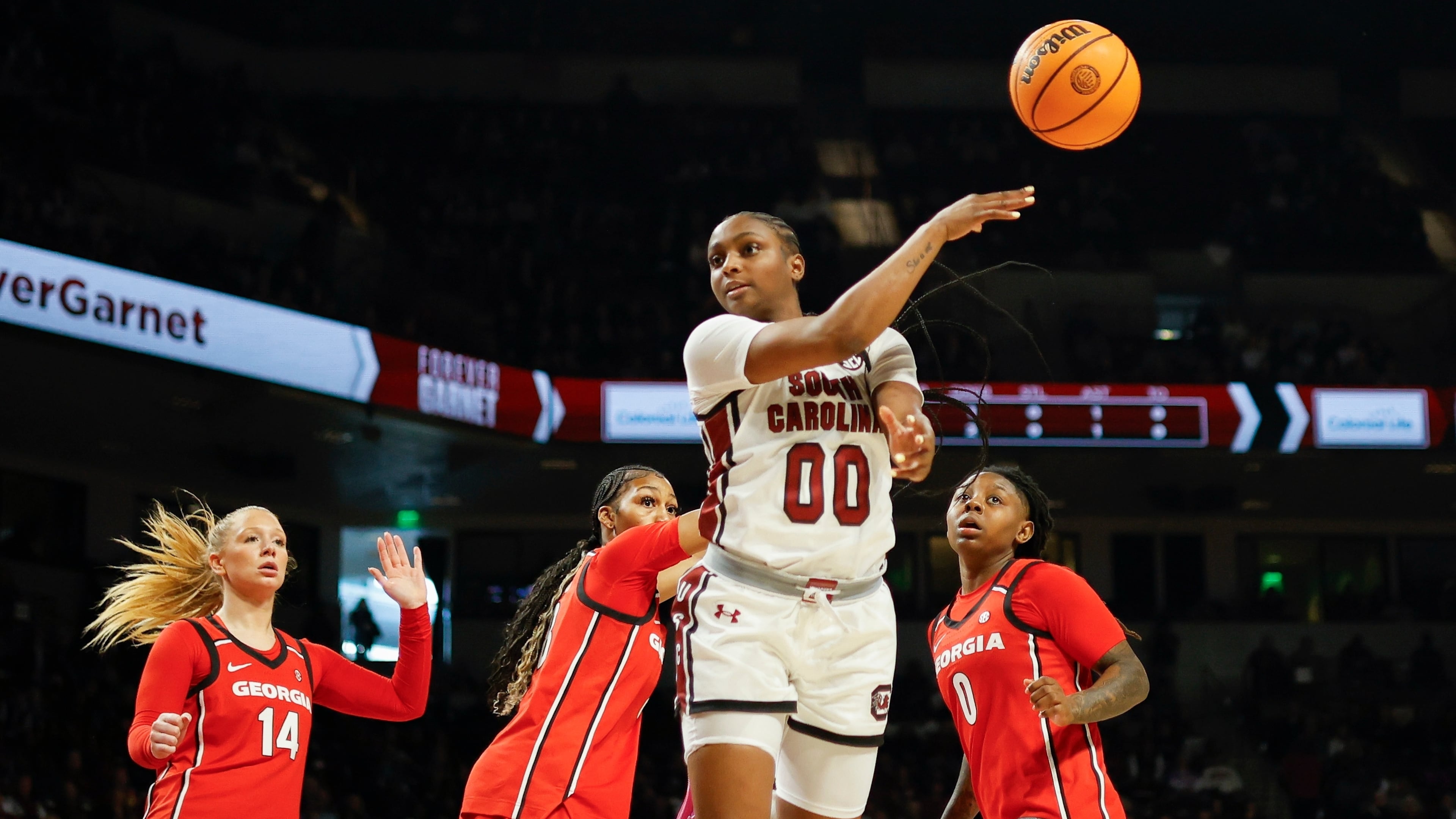 South Carolina guard Ta'Niya Latson (00) passes the ball ahead of Georgia guard Rylie Theuerkauf (14), forward Zhen Craft, second from left, and guard Trinity Turner (0) during the first half of an NCAA college basketball game in Columbia, S.C., Sunday, Jan. 11, 2026. (AP Photo/Nell Redmond)