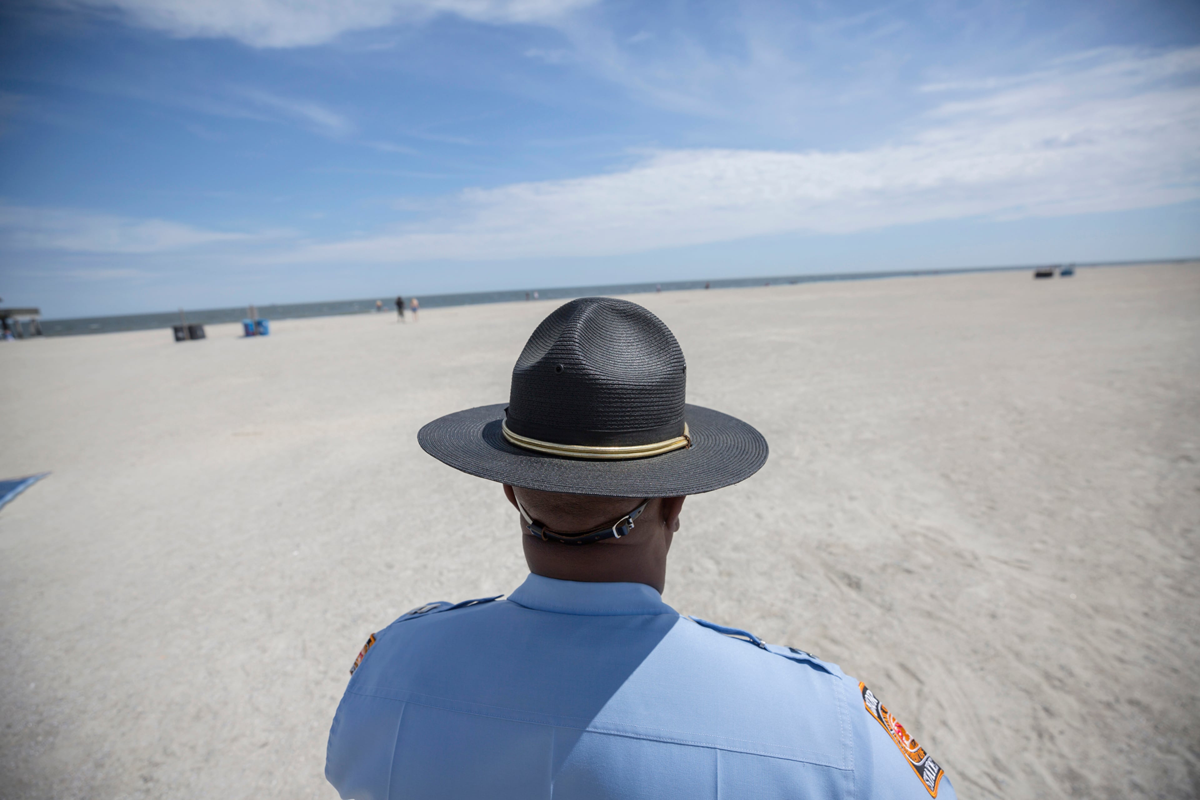 Georgia State Patrol Capt. Thornell King watches visitors to Tybee Island beach on Saturday, April 4, 2020, after Gov. Brian Kemp signed an executive order allowing people to exercise outside, with social distancing of at least 6 feet. (Stephen B. Morton/Special to the AJC)